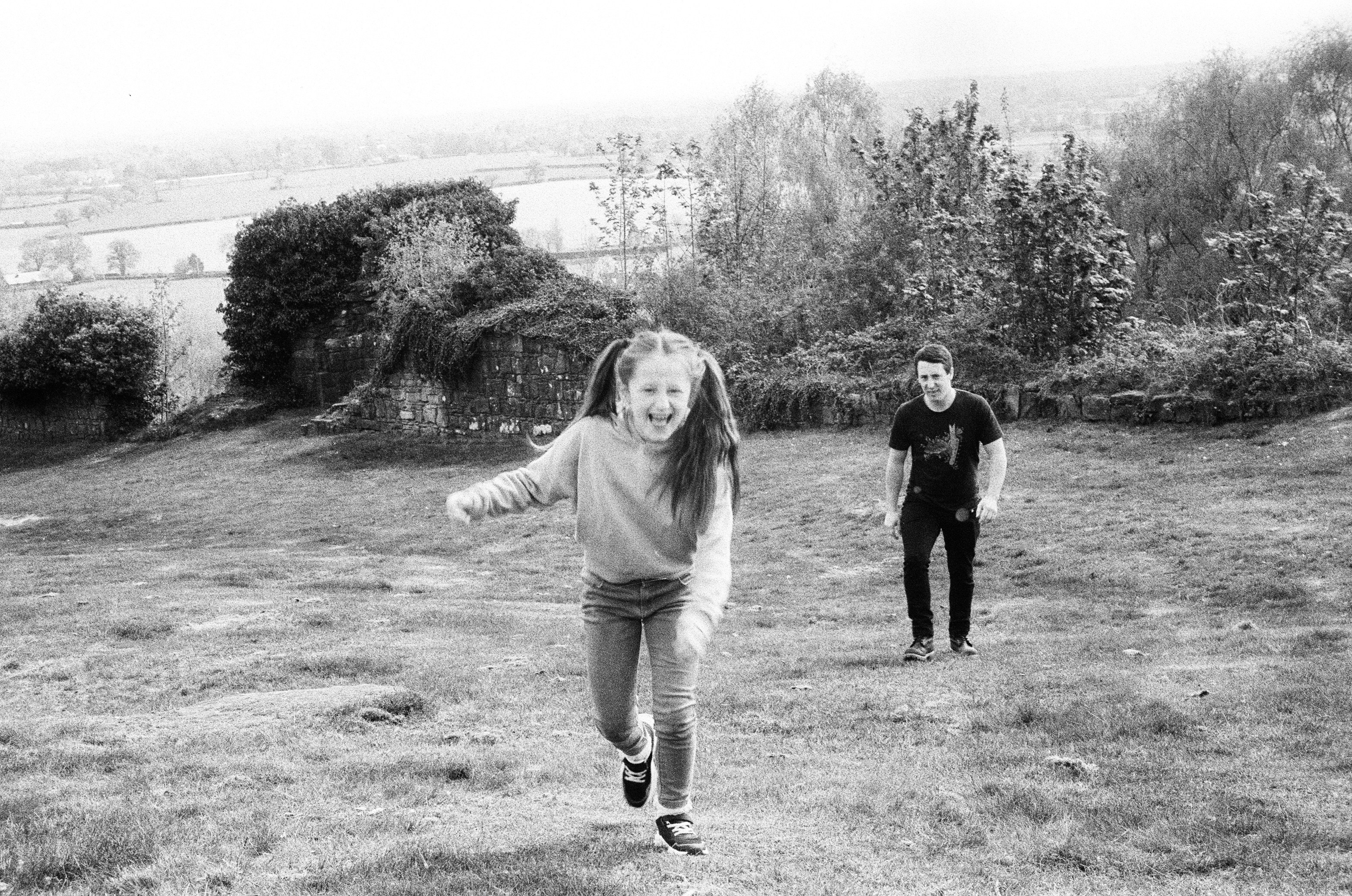 Girl running towards camera with man behind her