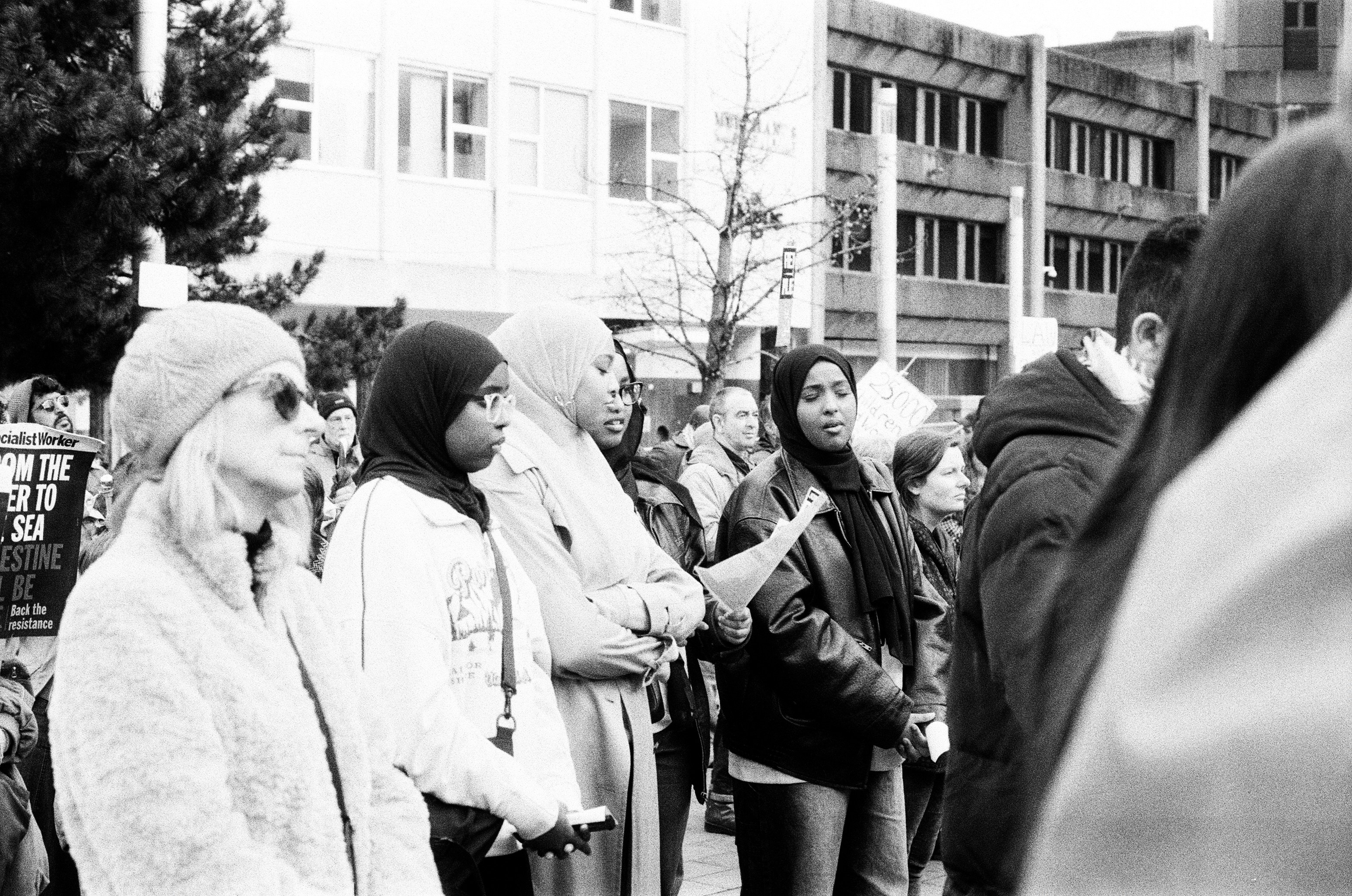 A diverse group of people stand together outdoors.