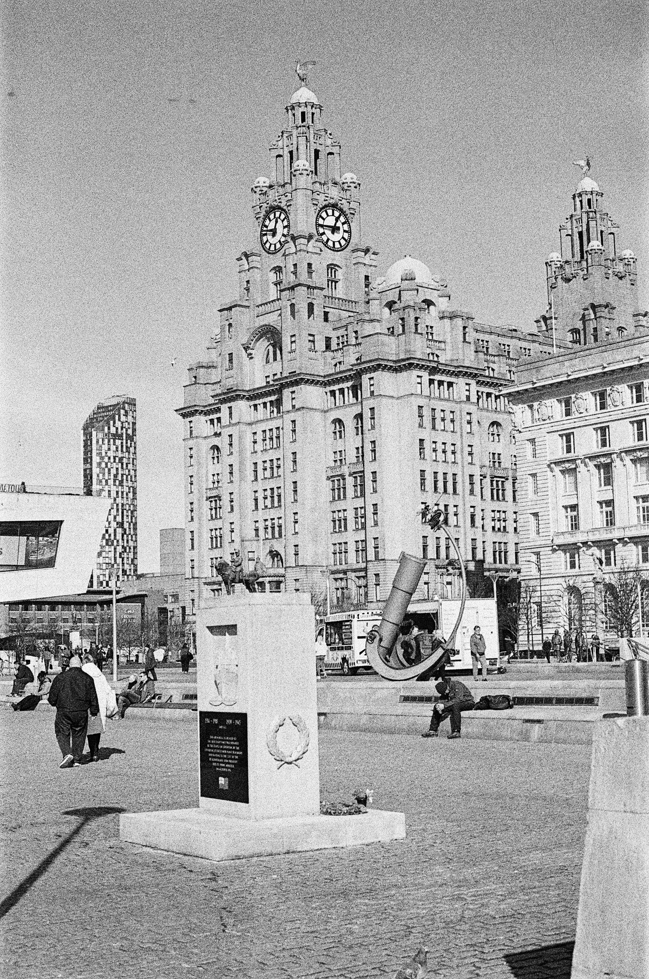 A monument stands before a grand building.