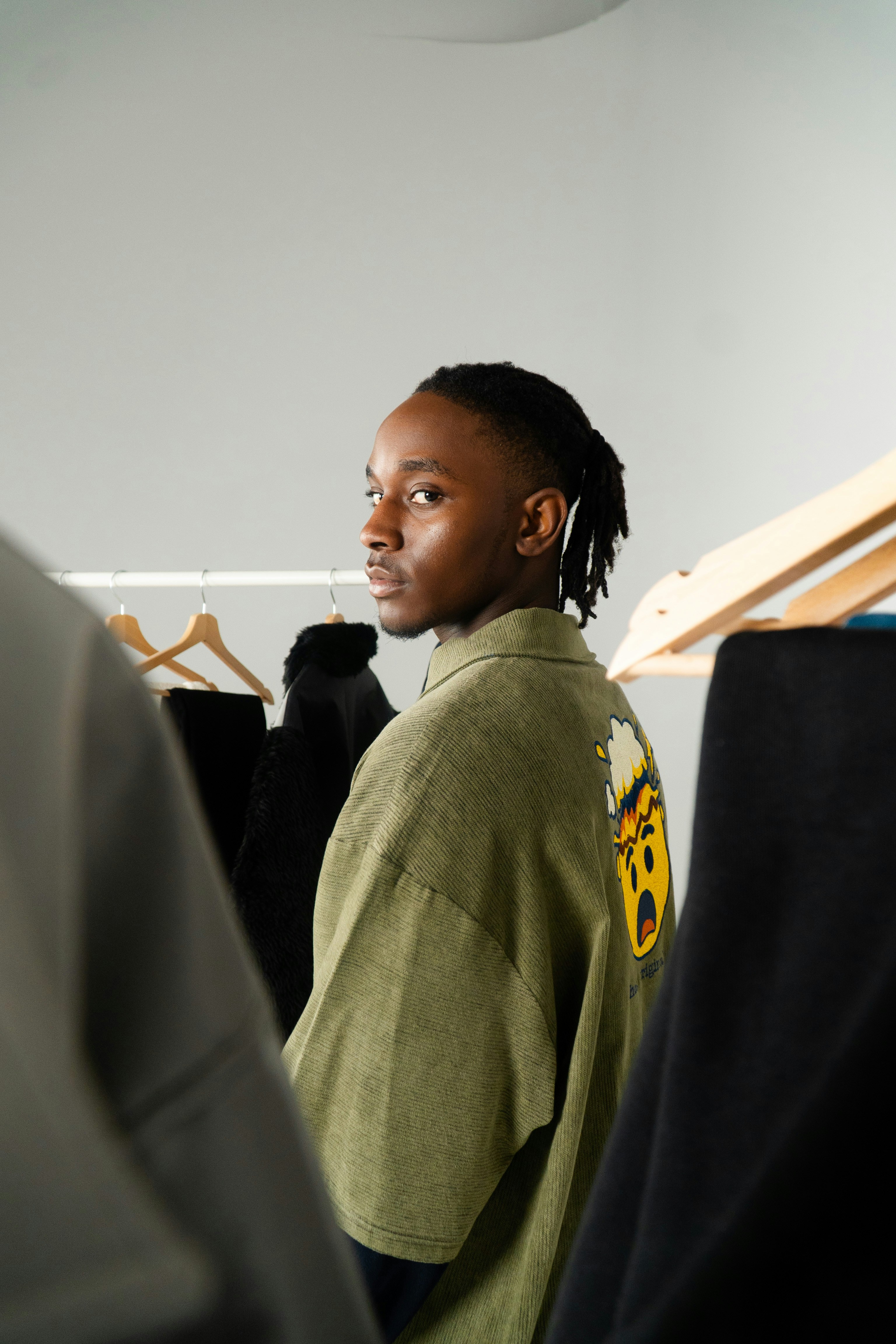 Young man in olive shirt with graphic on back