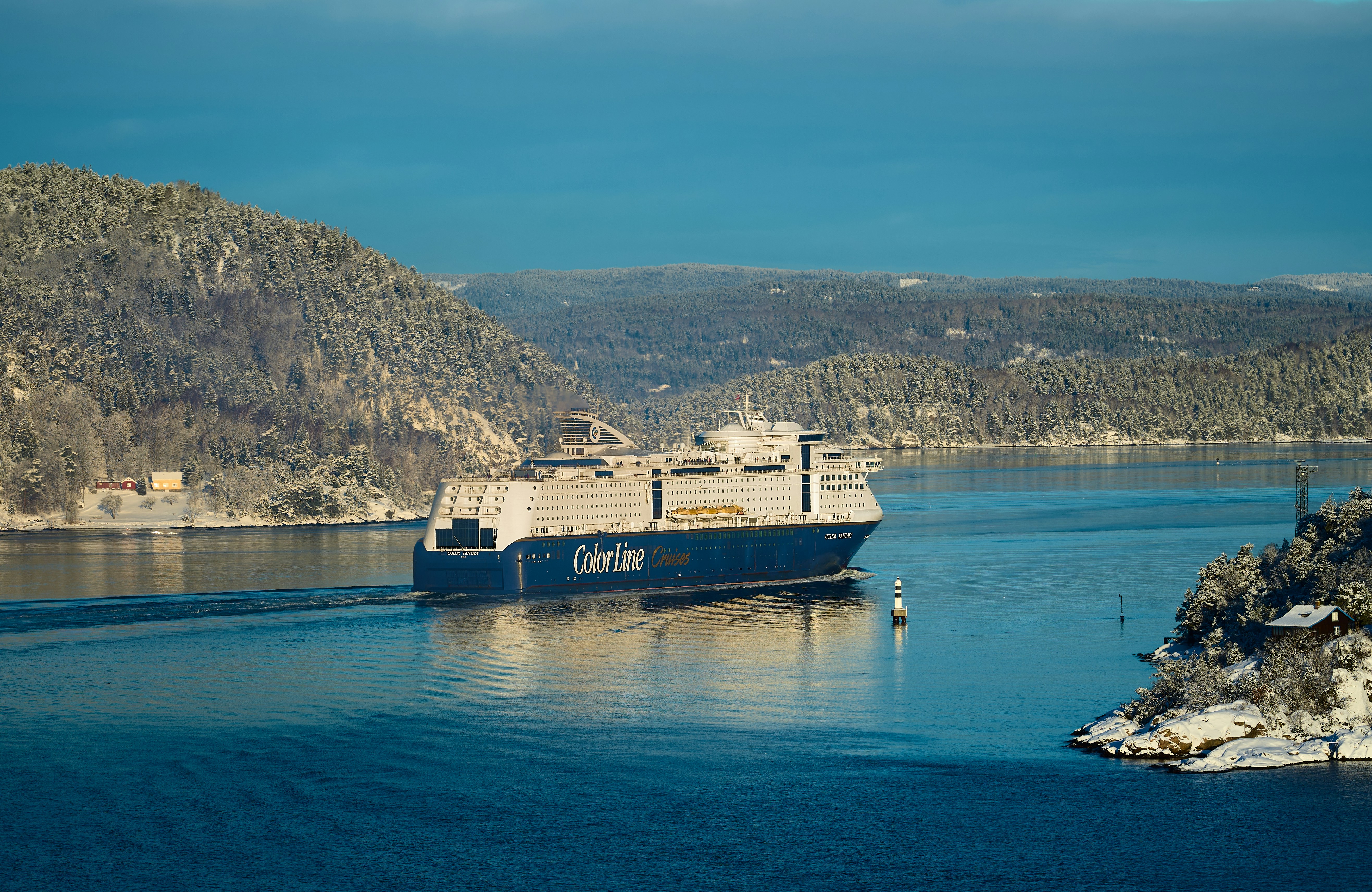 A large cargo ship sails on a calm blue sea.