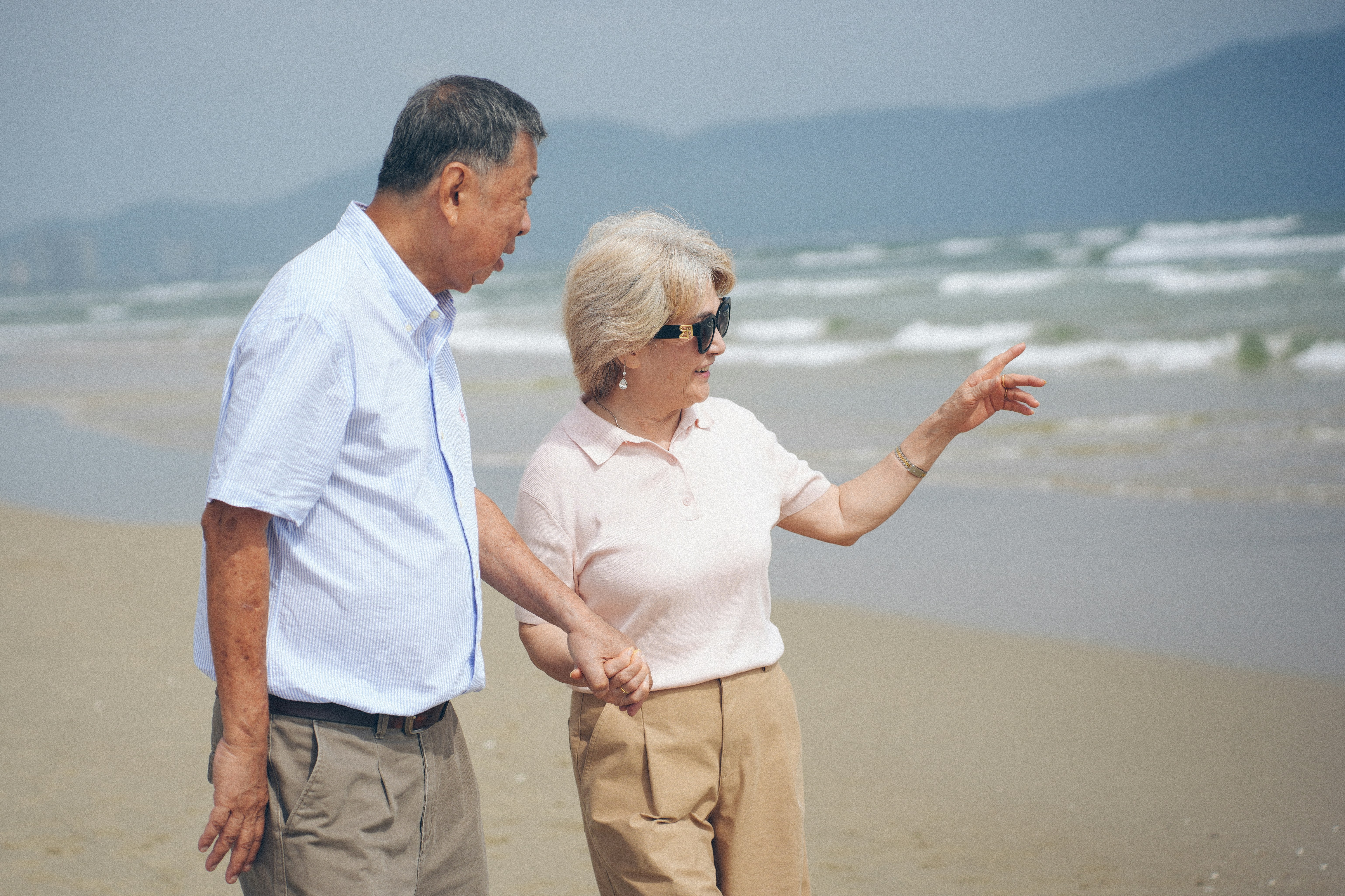Elderly couple walking on a sandy beach