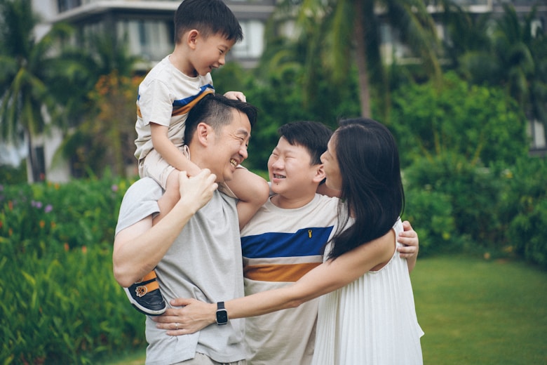 Happy family of four with two children smiling together outdoors