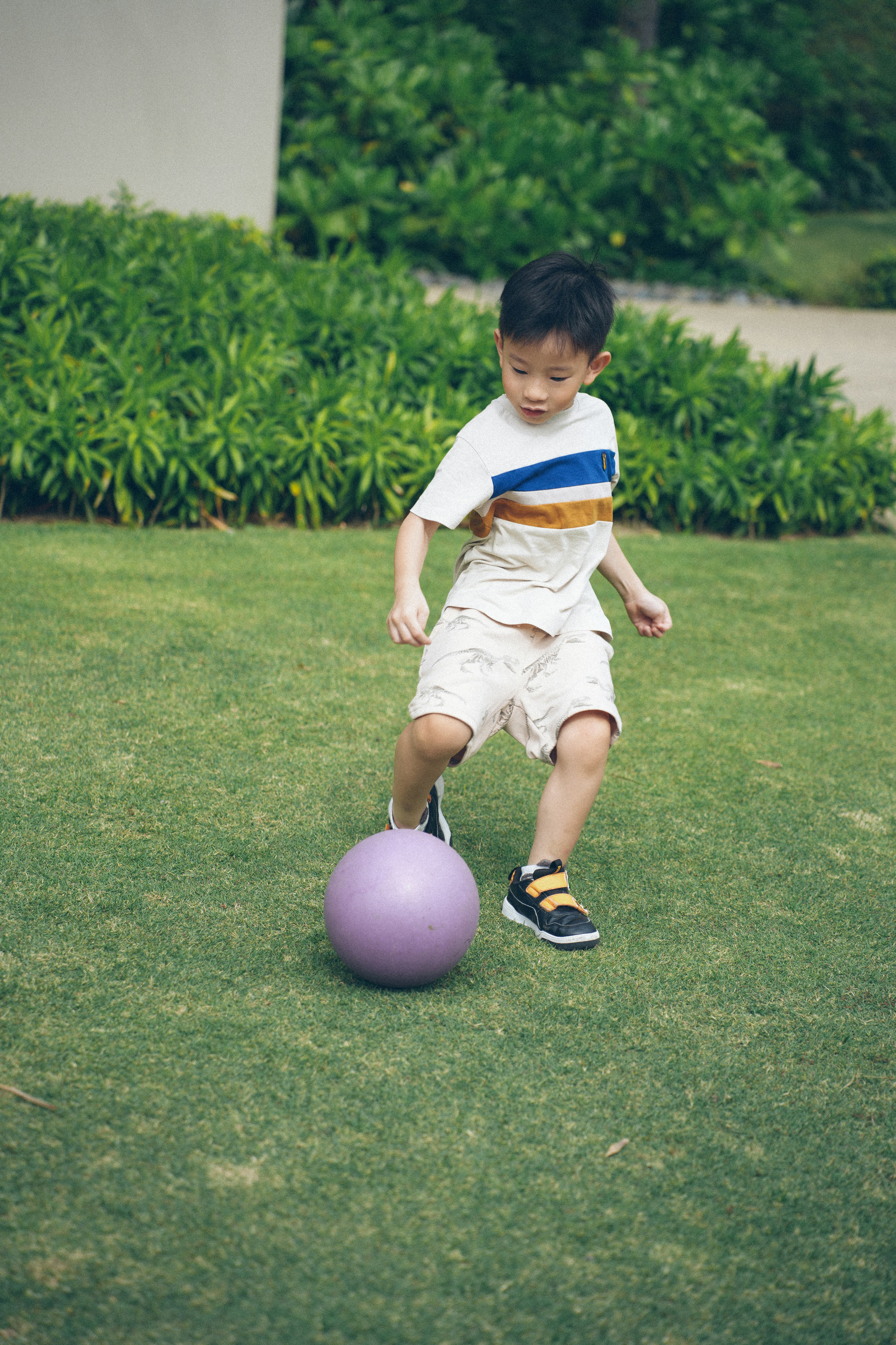 Young boy playing soccer on a grassy field.