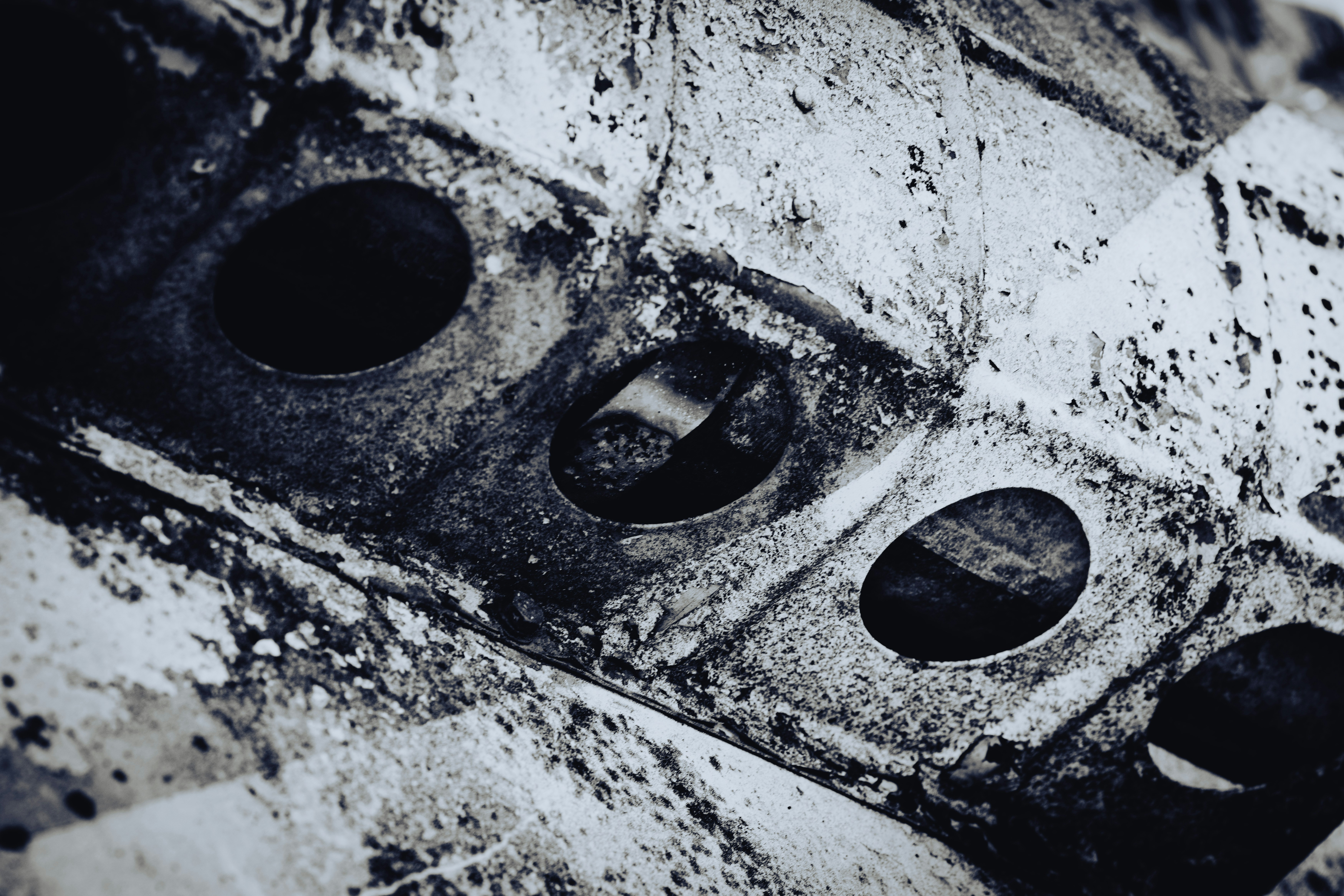 원형 구멍이 있는 낡고 질감 있는 금속 클로즈업.