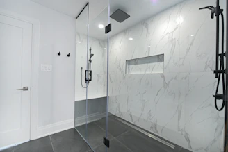Modern bathroom with glass-enclosed shower and marble walls in phoenix