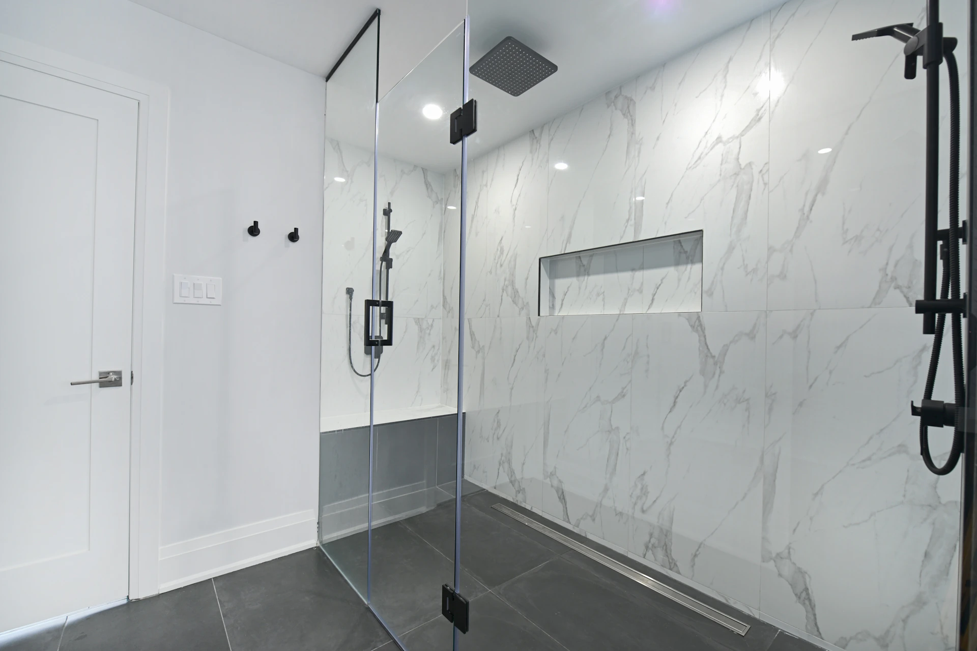 Modern bathroom with glass-enclosed shower and marble walls