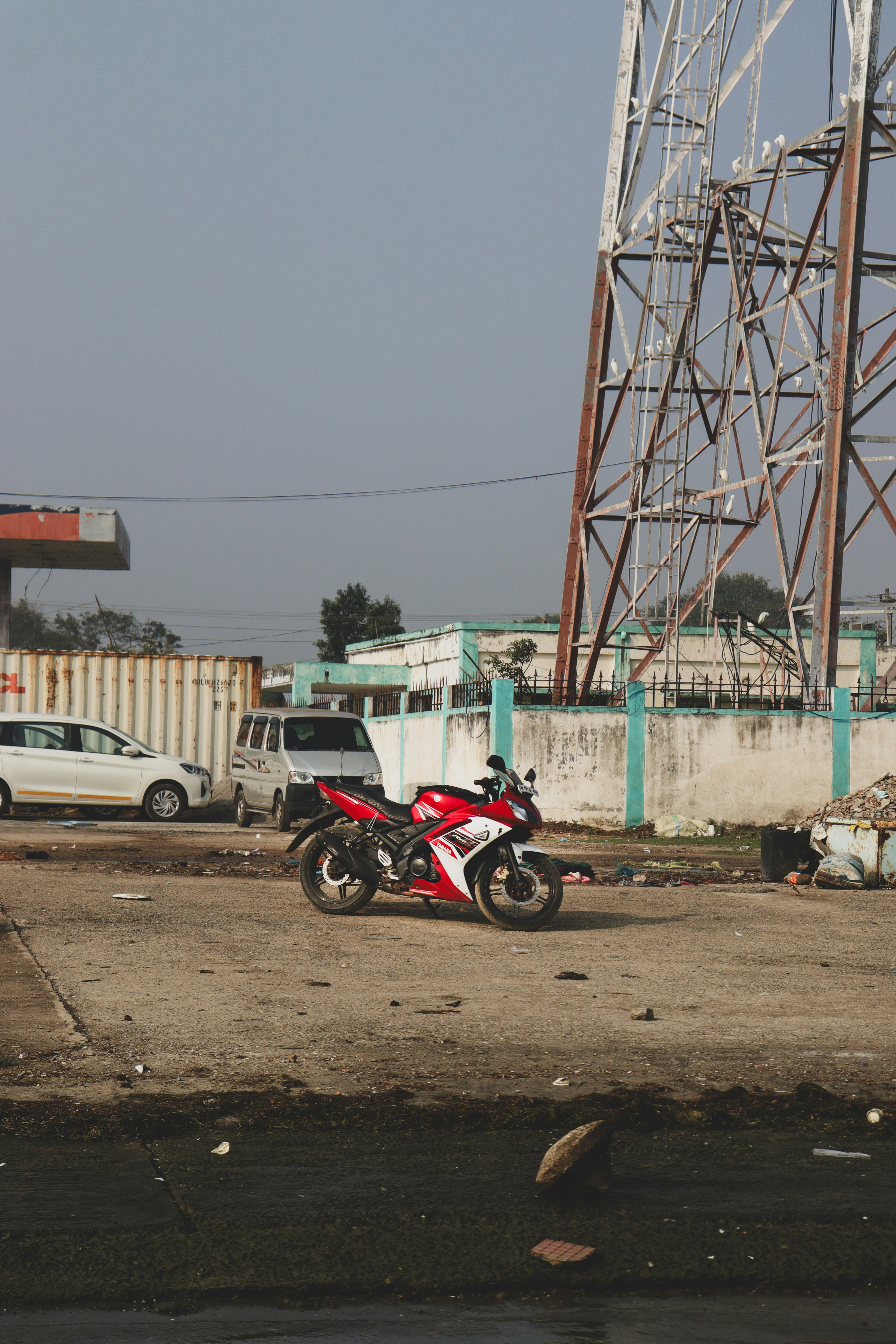 赤と白のバイクが未舗装の道に停まっている。