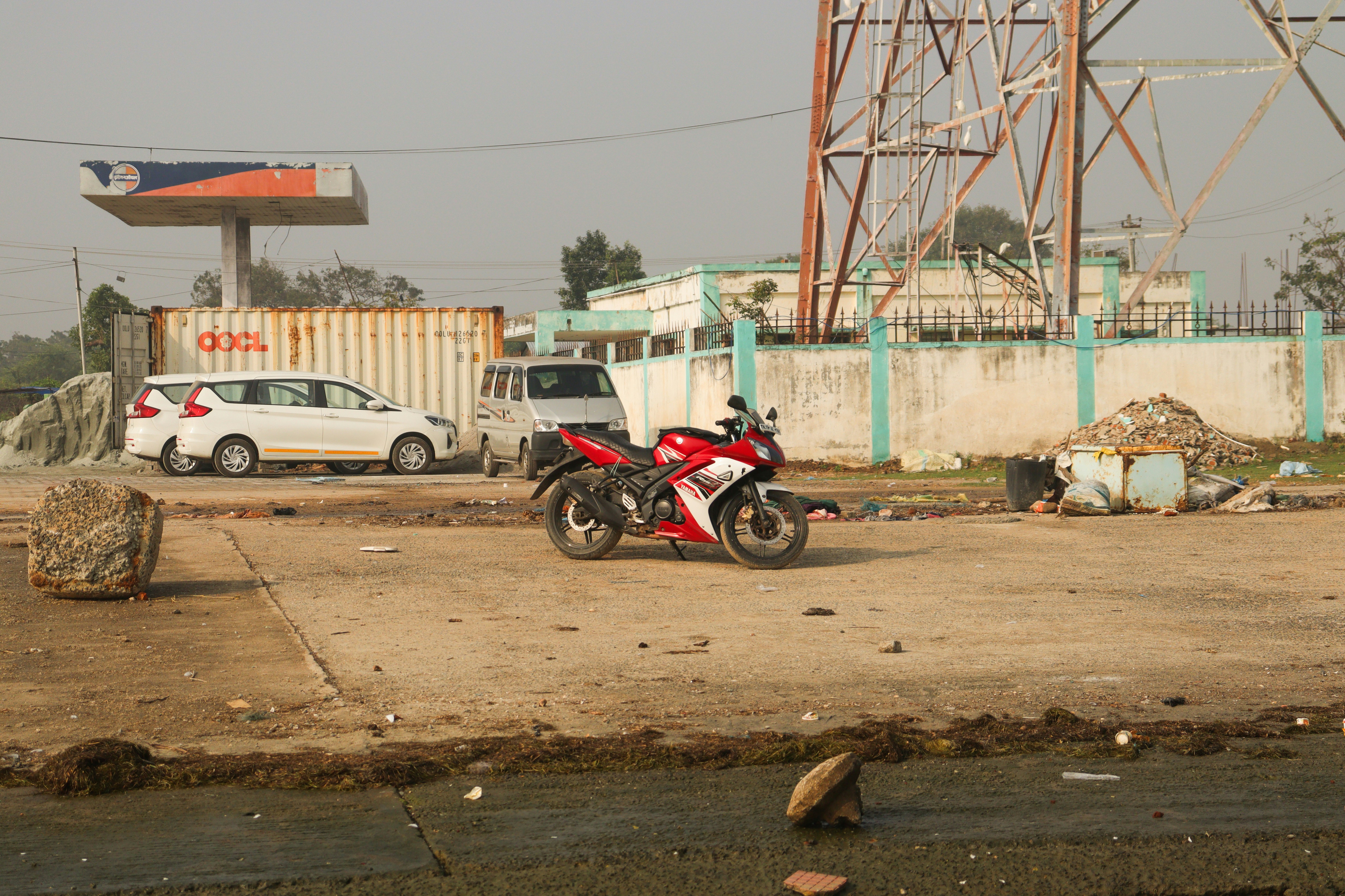 Sepeda motor merah diparkir di jalan yang kotor