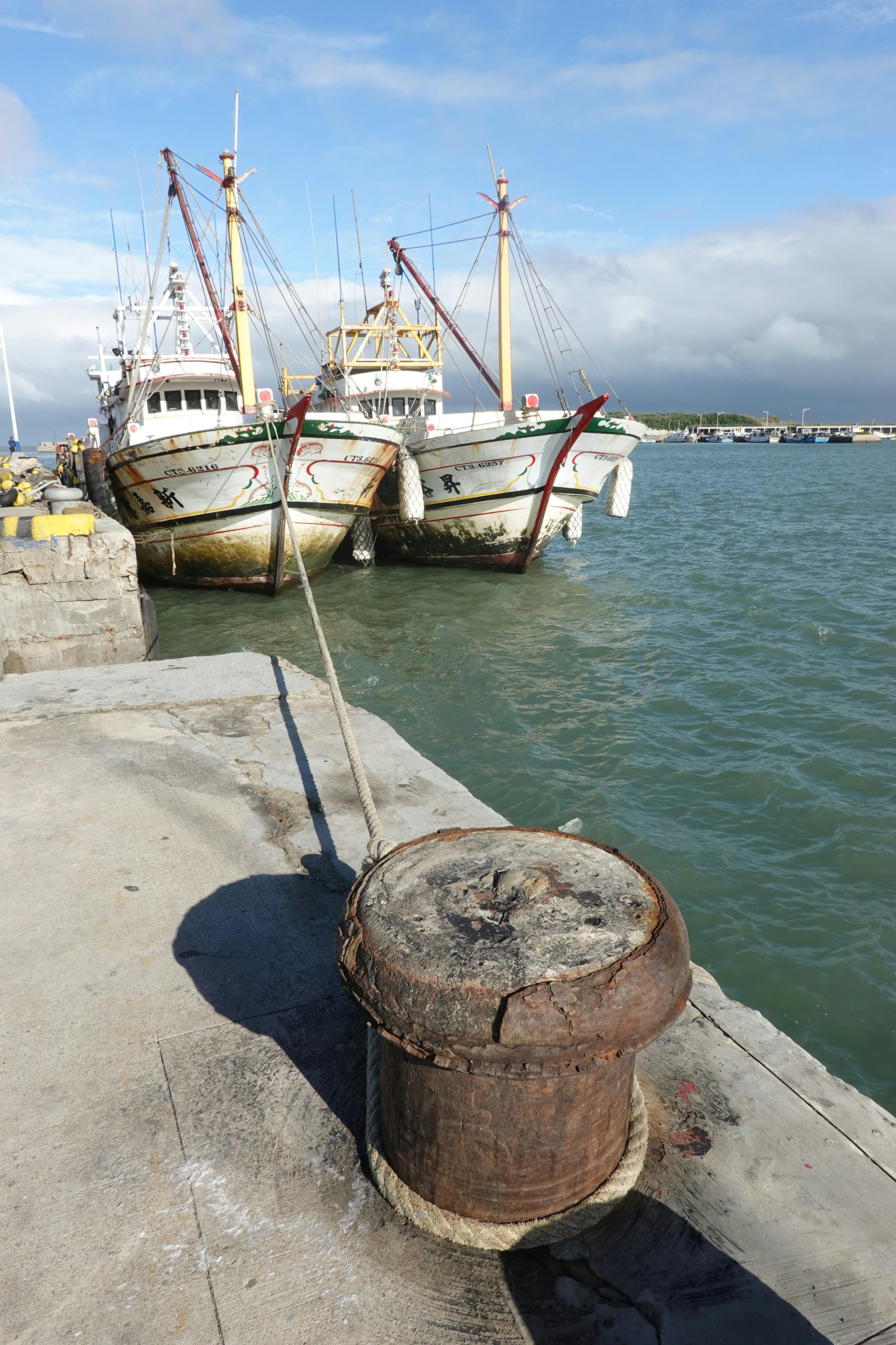 Two white fishing boats docked at a pier