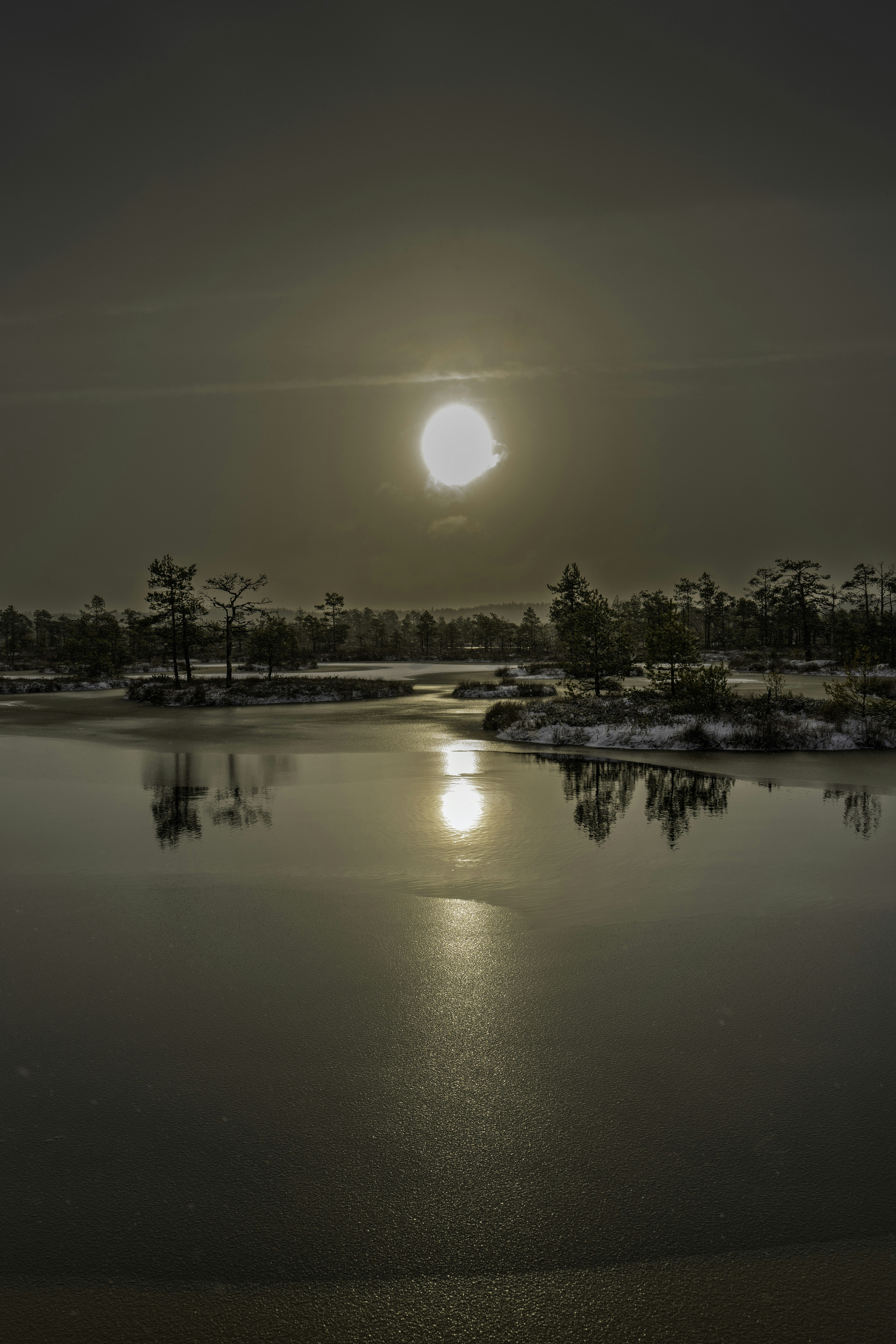 凍てついた雪の景色に沈む夕日が映り、反射が映っている。