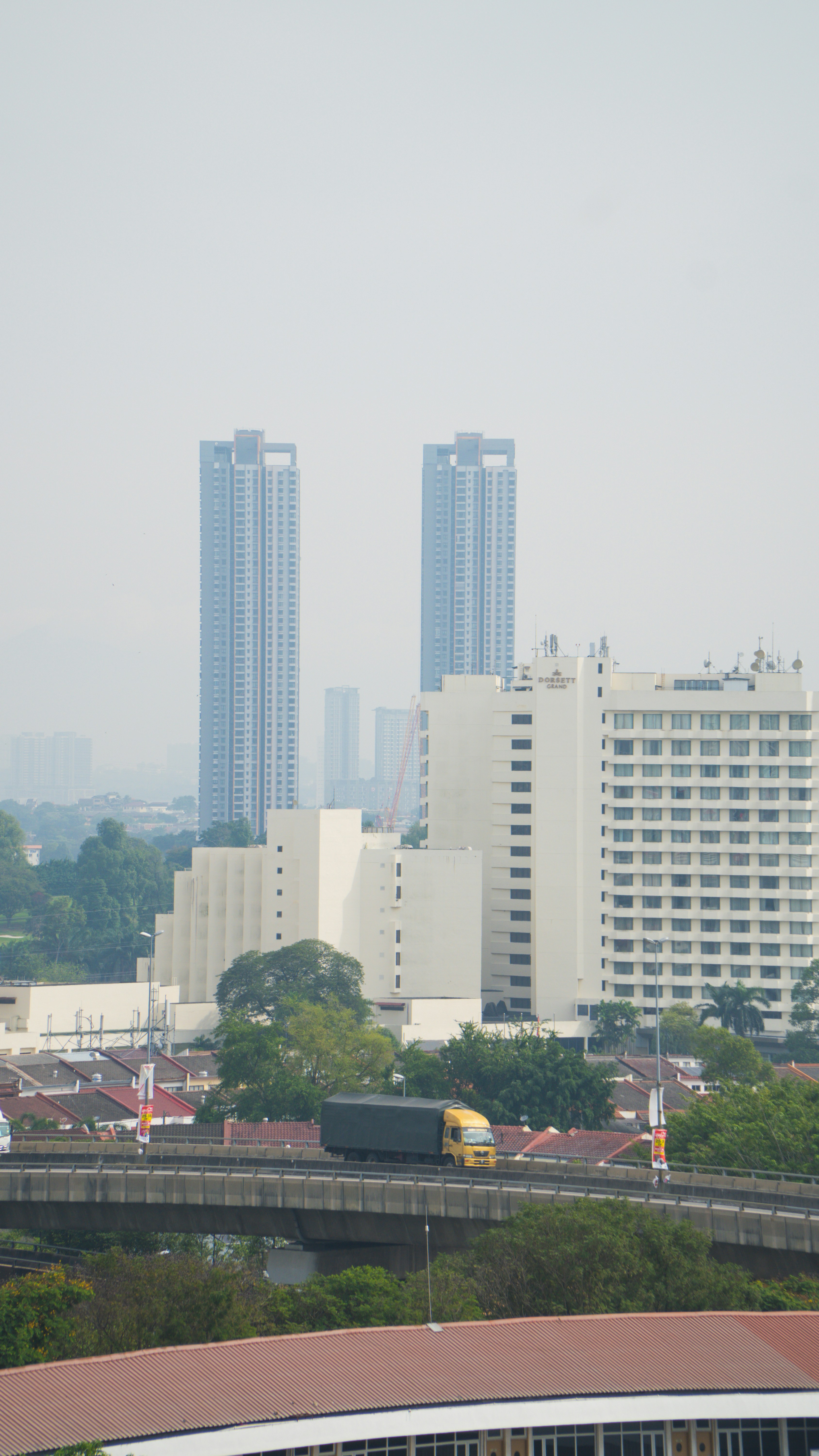 A yellow truck drives on a railway bridge.