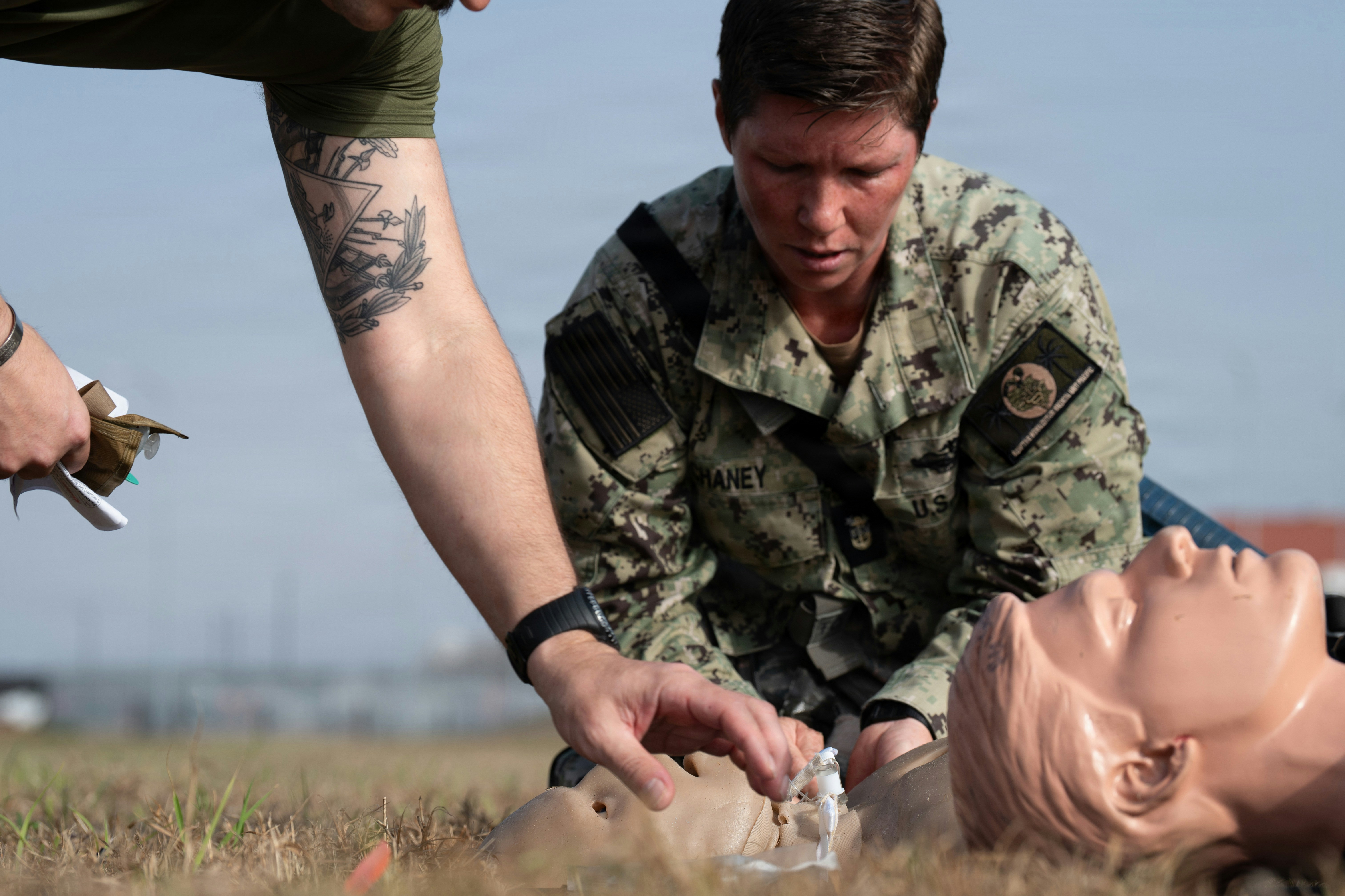 Medical professionals practice cpr on mannequins outdoors.