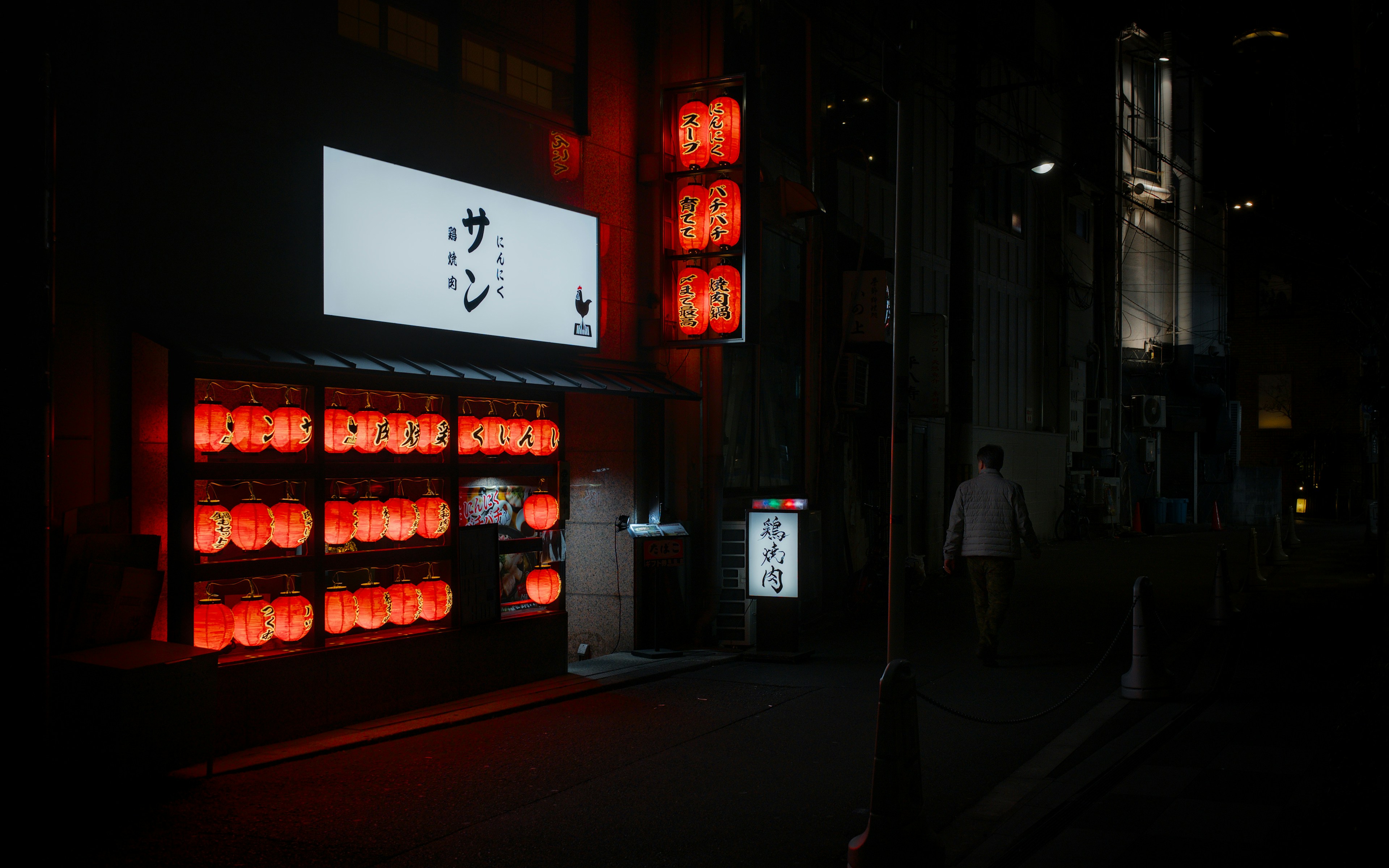 Japanese street at night with glowing lanterns and signs