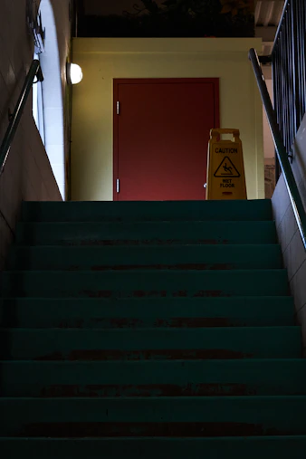 A caution wet floor sign stands on stairs.