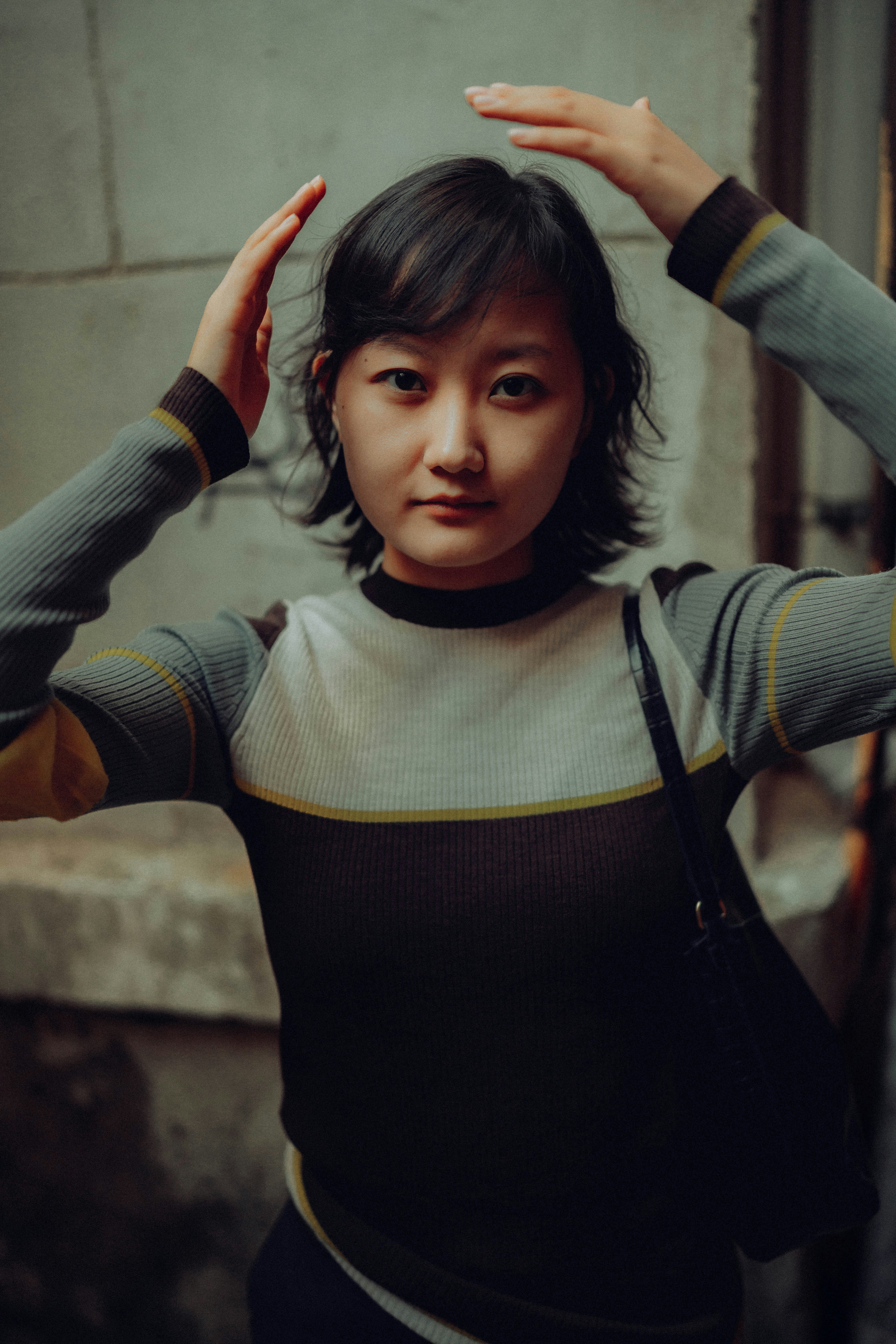 Young woman with hands on head looking at camera