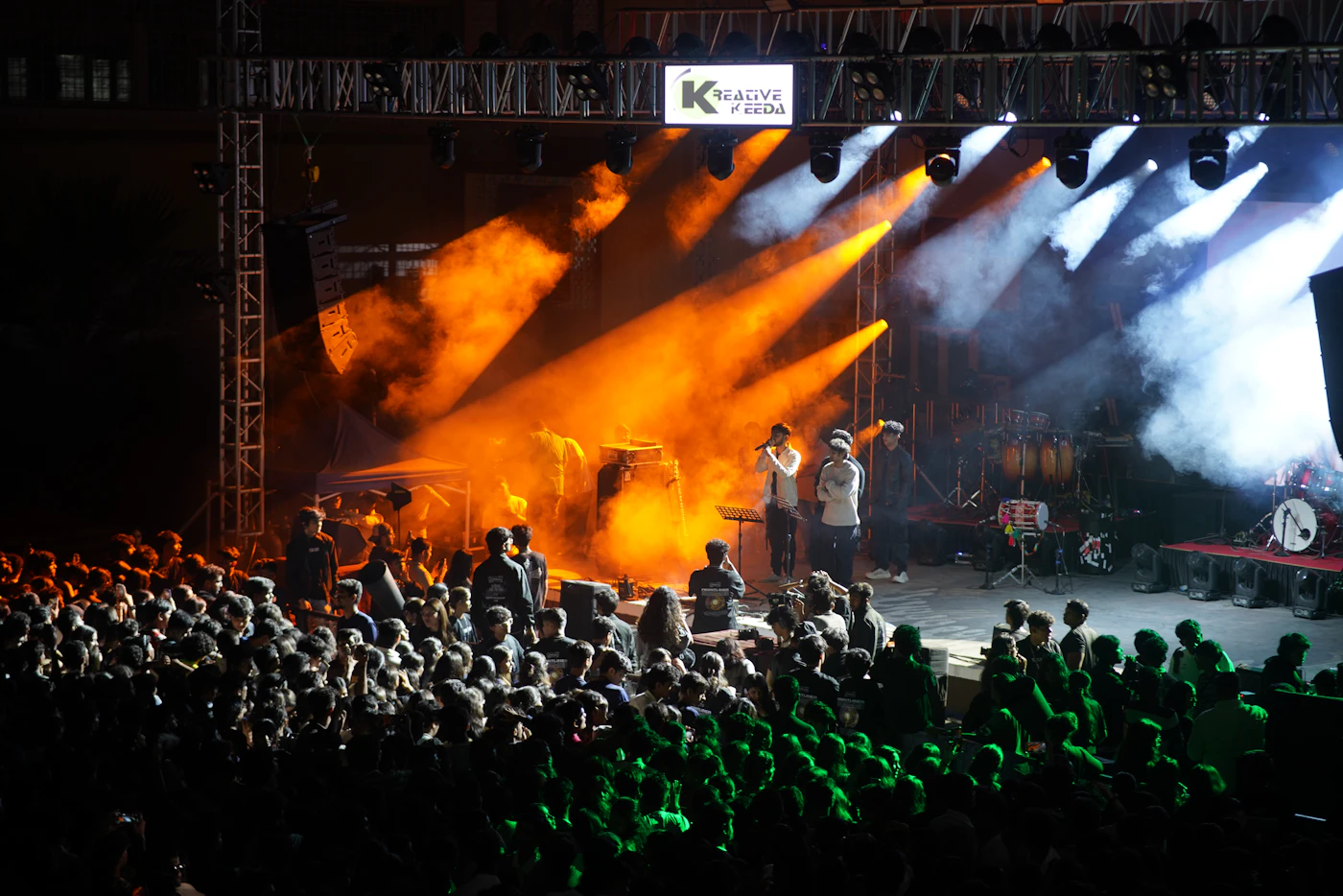 Band performing on stage with bright lights before an audience