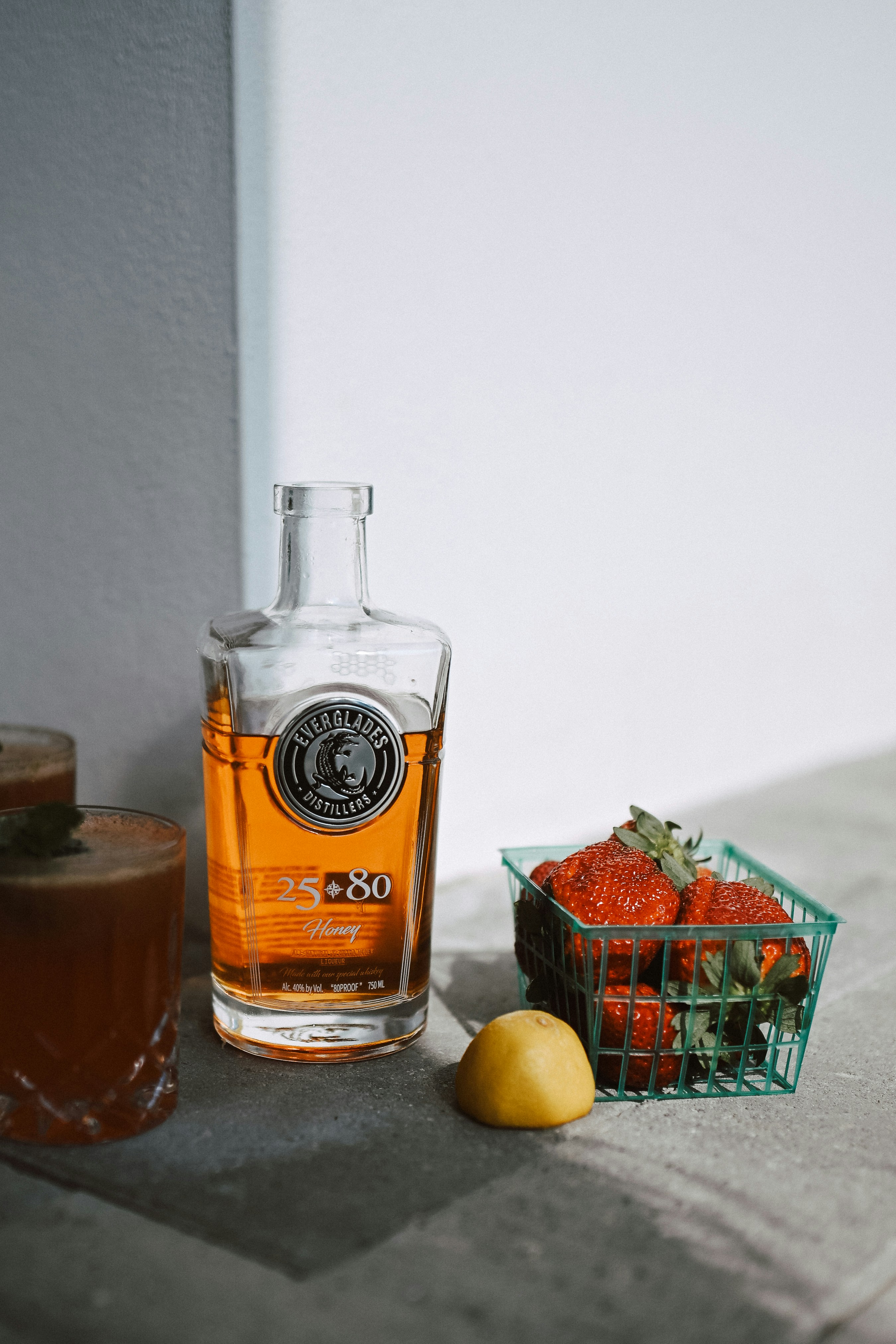 Garrafa de bebida com morangos, limão e bebidas.