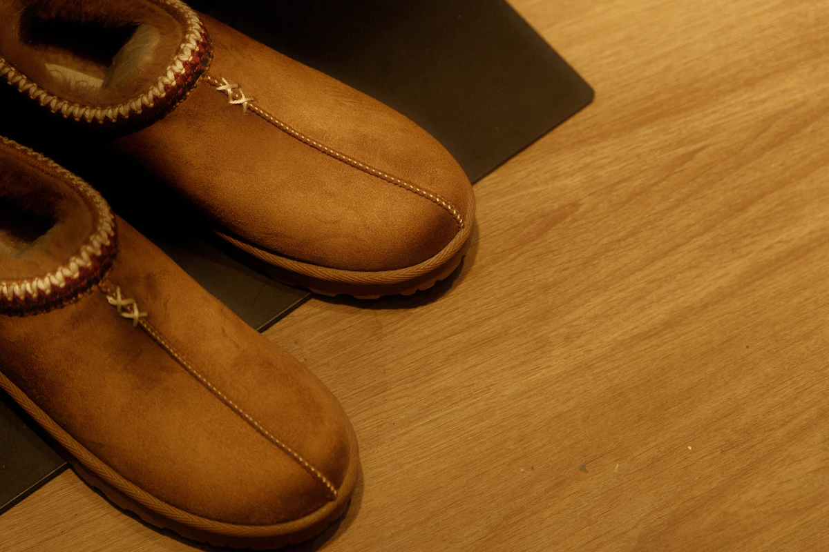 Warme pantoffels op een houten vloer, geschikt beschermend schoeisel in huis.