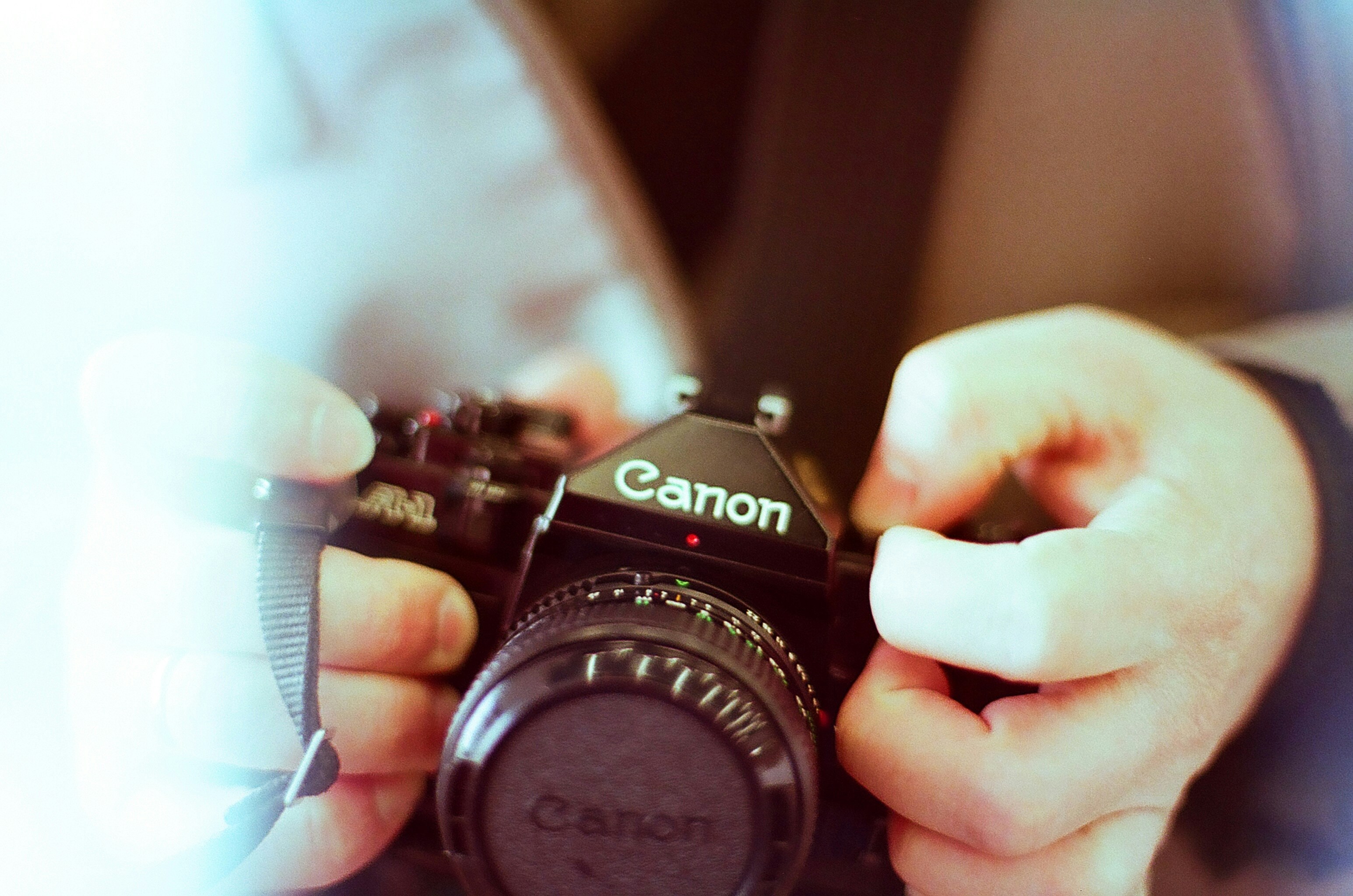 Hands holding a vintage canon camera