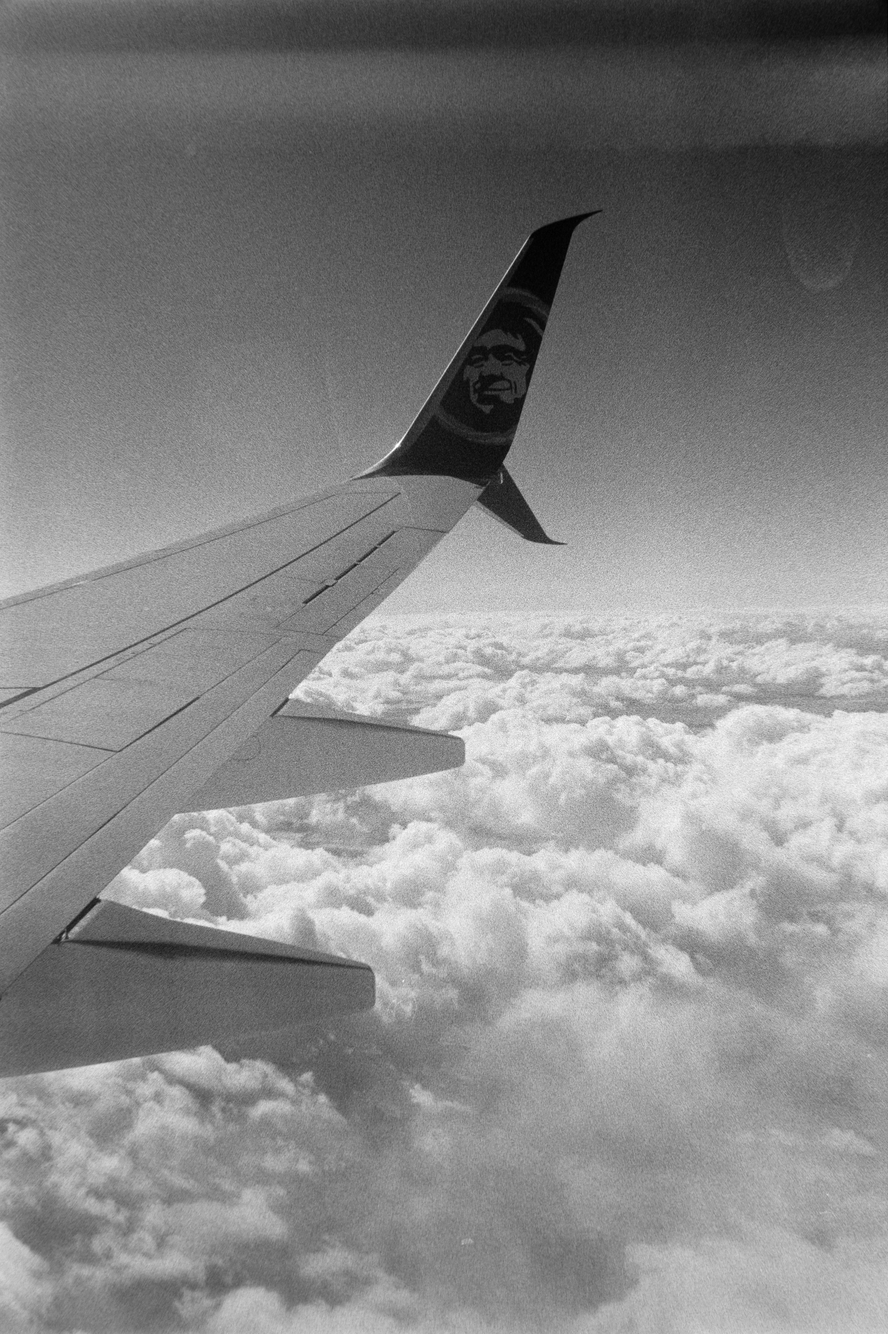 Airplane wing flying over clouds