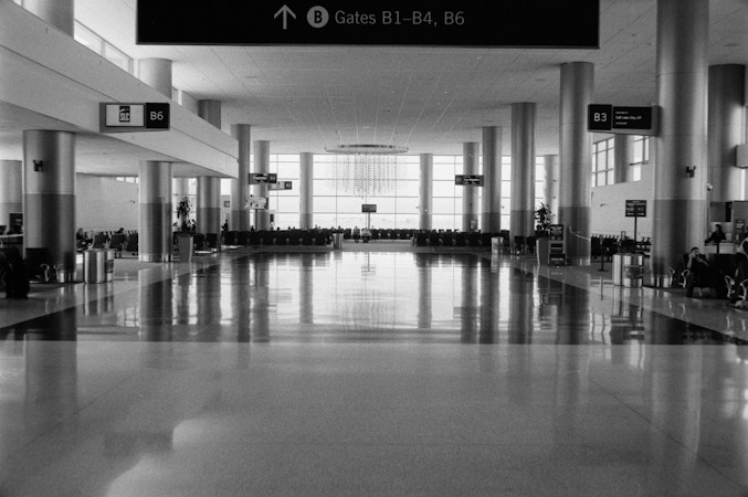 A bright, open airport terminal with large windows and rows of gate seating, the kind of larger hold rooms planned for the new Terminal 1 gates