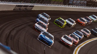 Stock cars racing on a track during a competition.