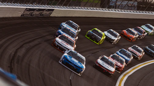 Stock cars racing on a track during a competition.