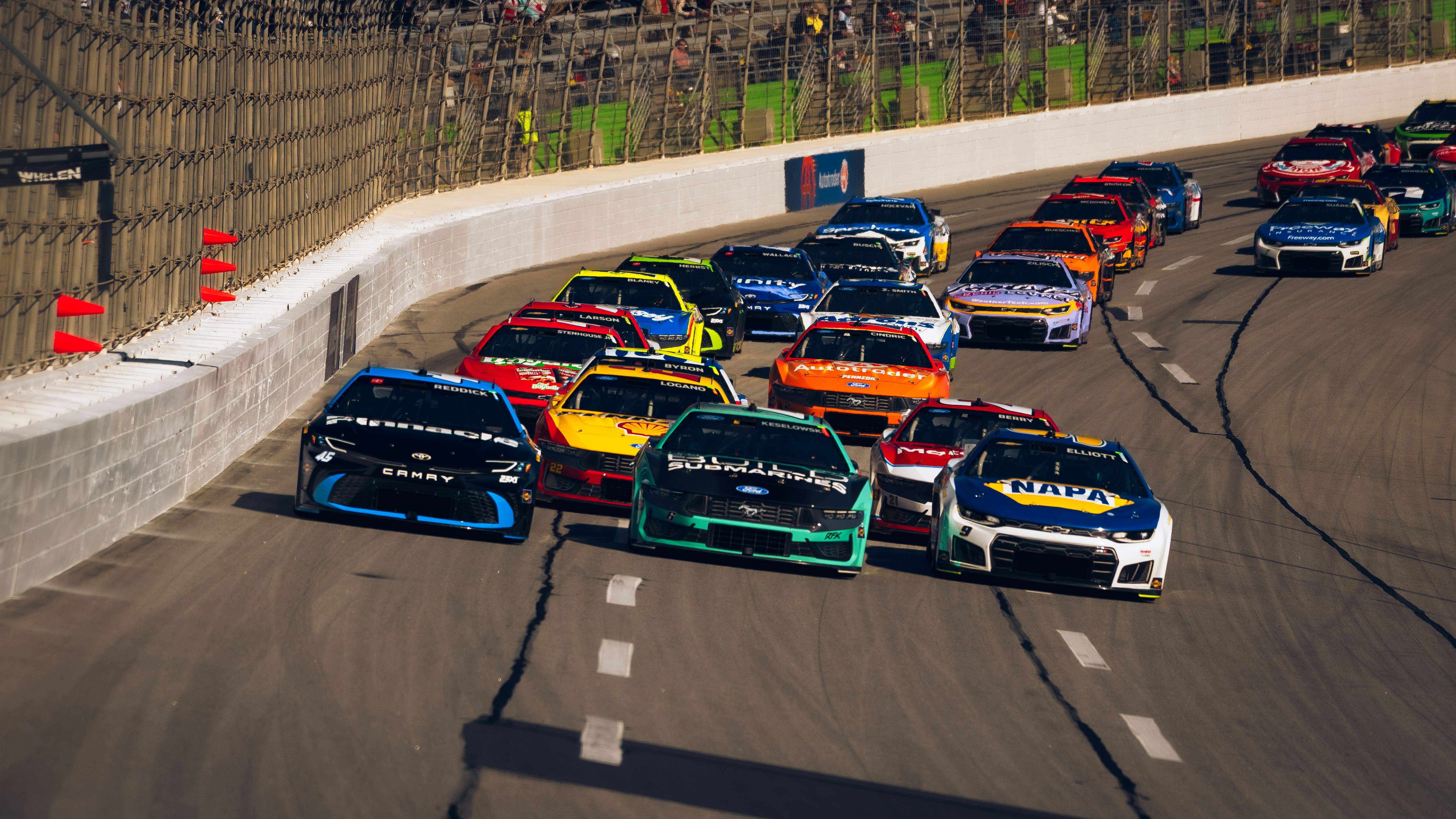 Stock Cars rennen eng auf einer asphaltierten Strecke.