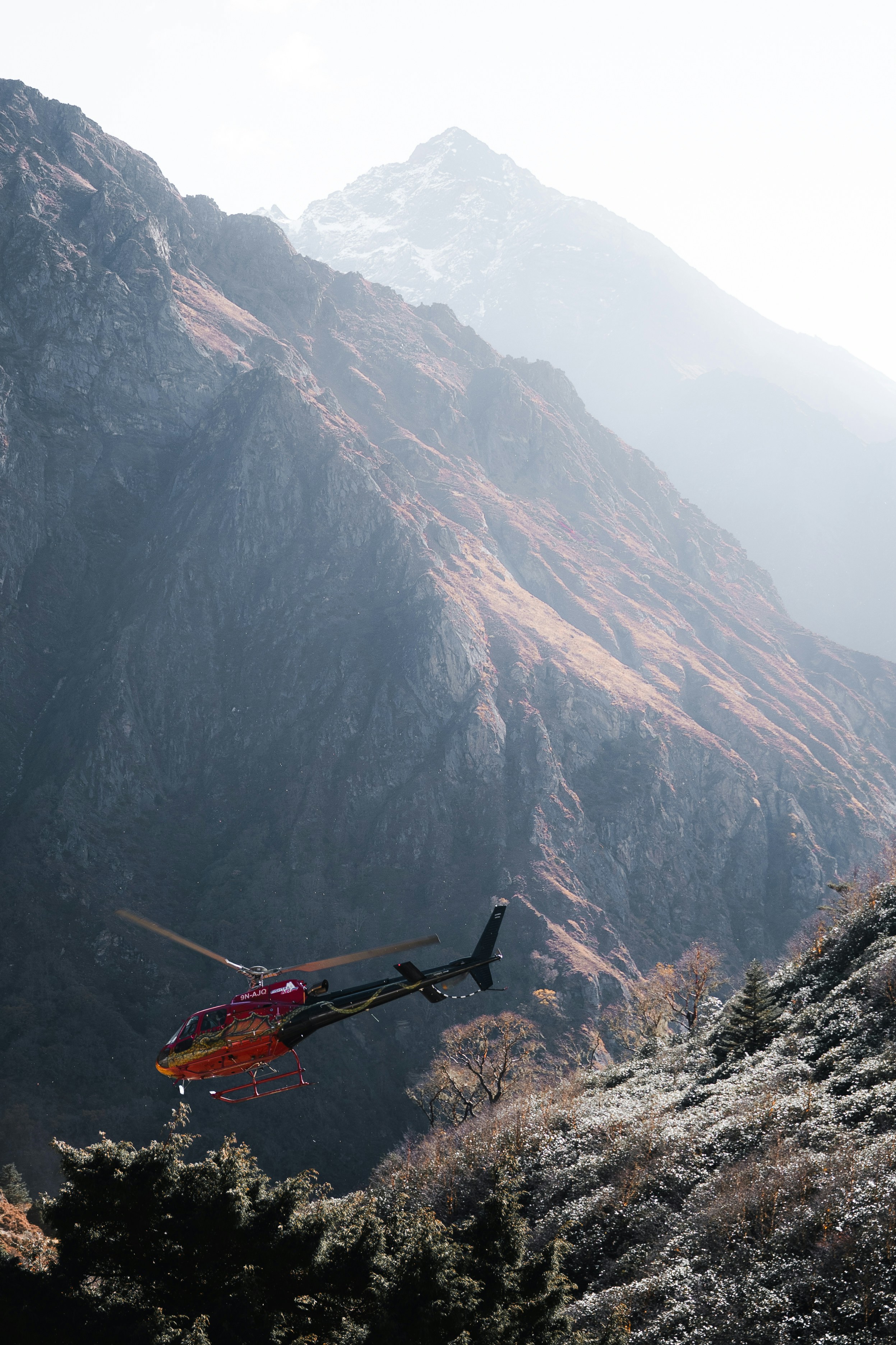 Ein Hubschrauber fliegt durch eine bergige Landschaft.