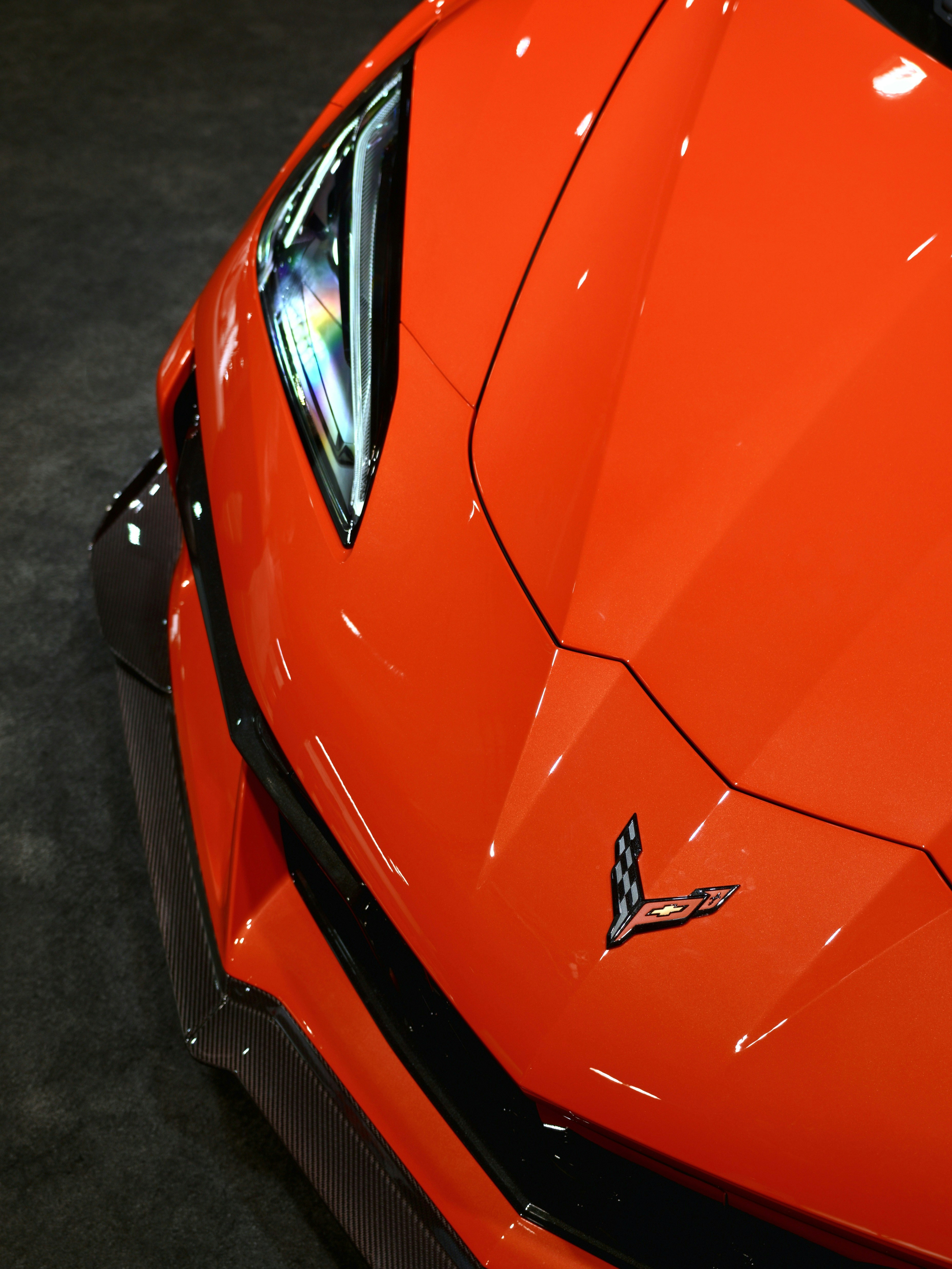 Close-up of an orange sports car's front emblem.