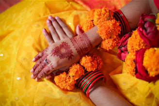 Bride's hands adorned with henna and marigold flowers