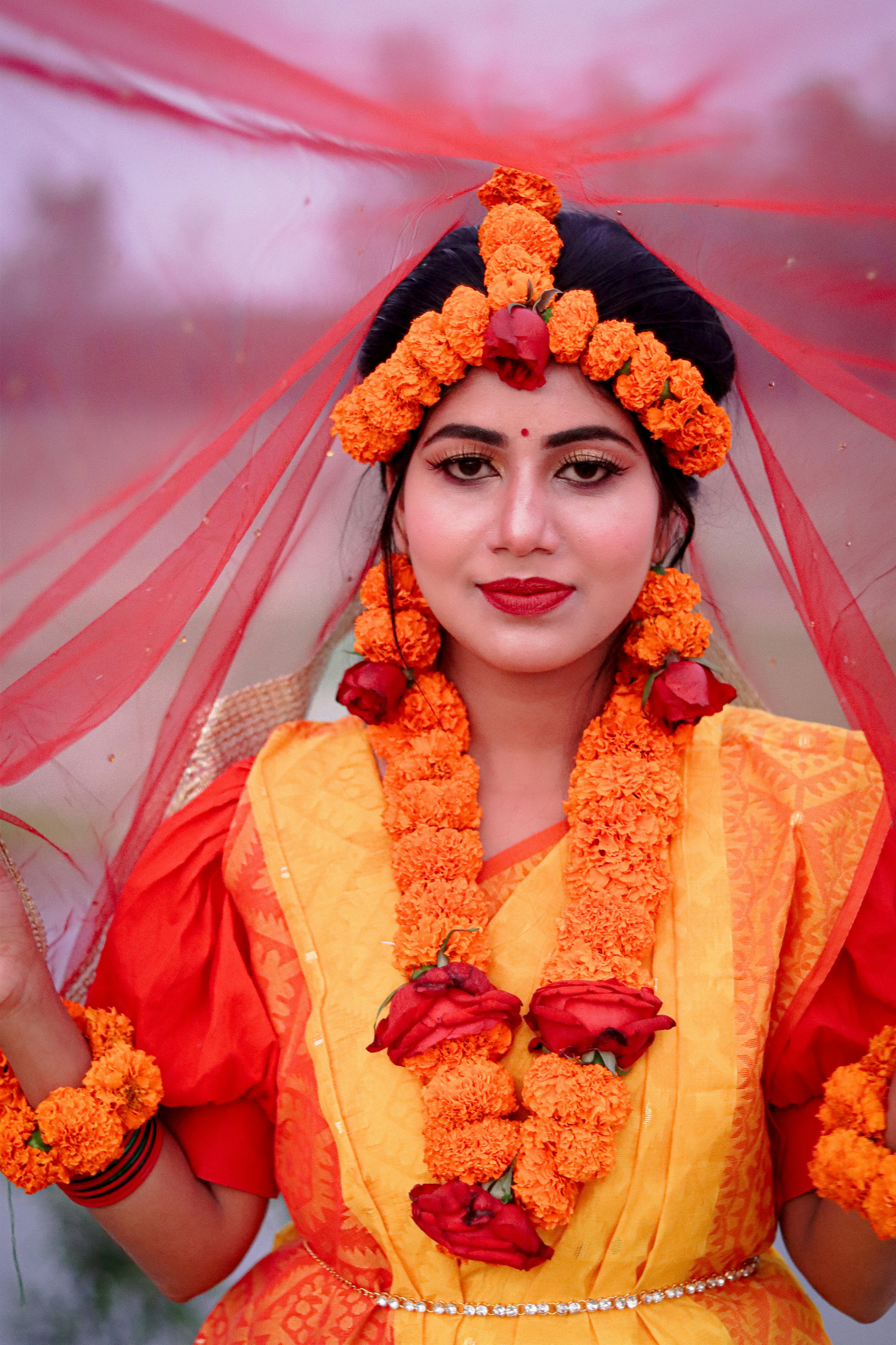 Una mujer con atuendos tradicionales adornados con flores de caléndula.