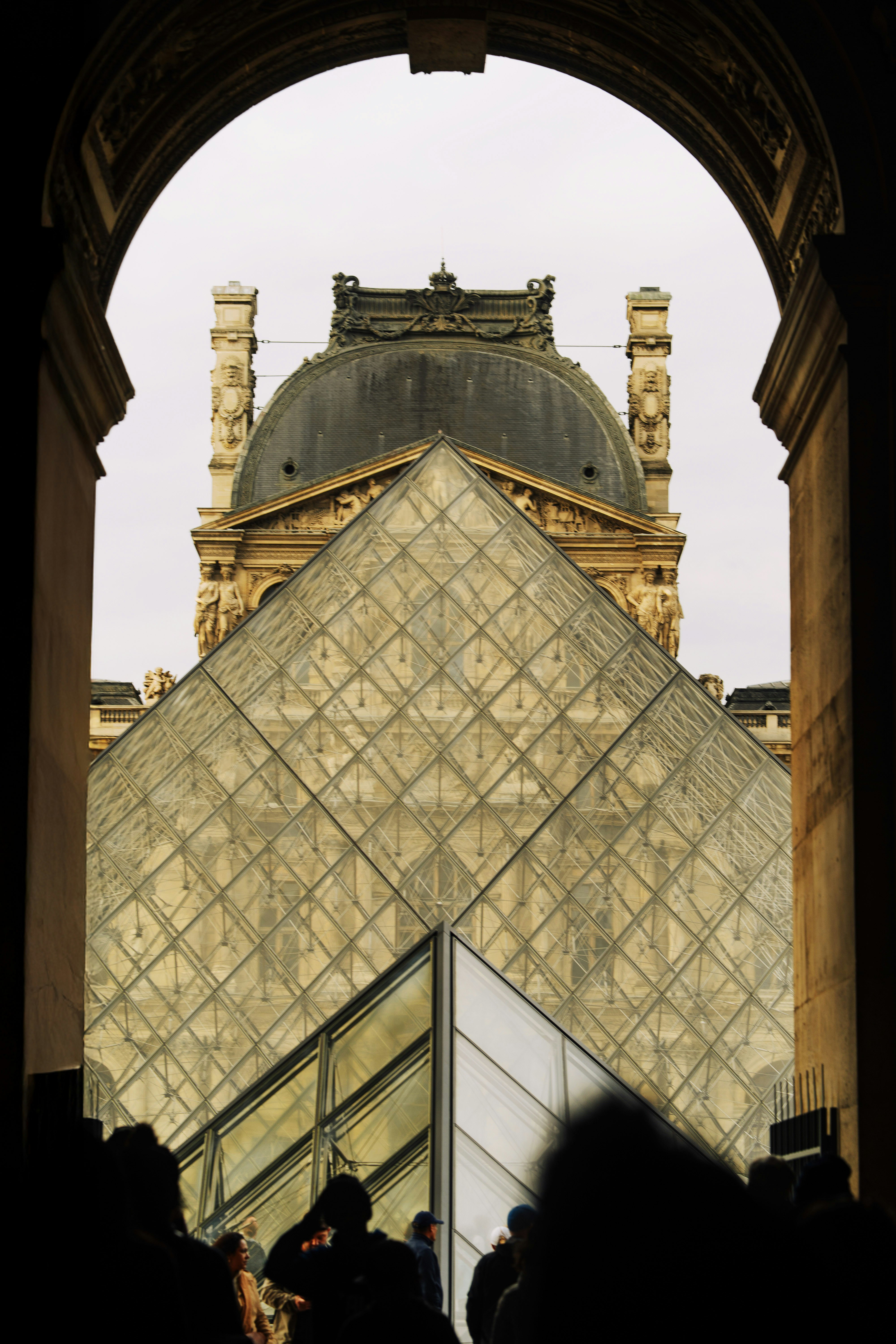 Louvre-Museumspyramide, durch einen Torbogen in Paris gesehen