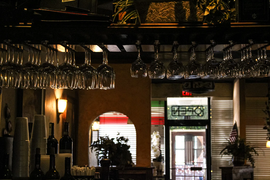 Wine glasses hanging above a dimly lit restaurant interior
