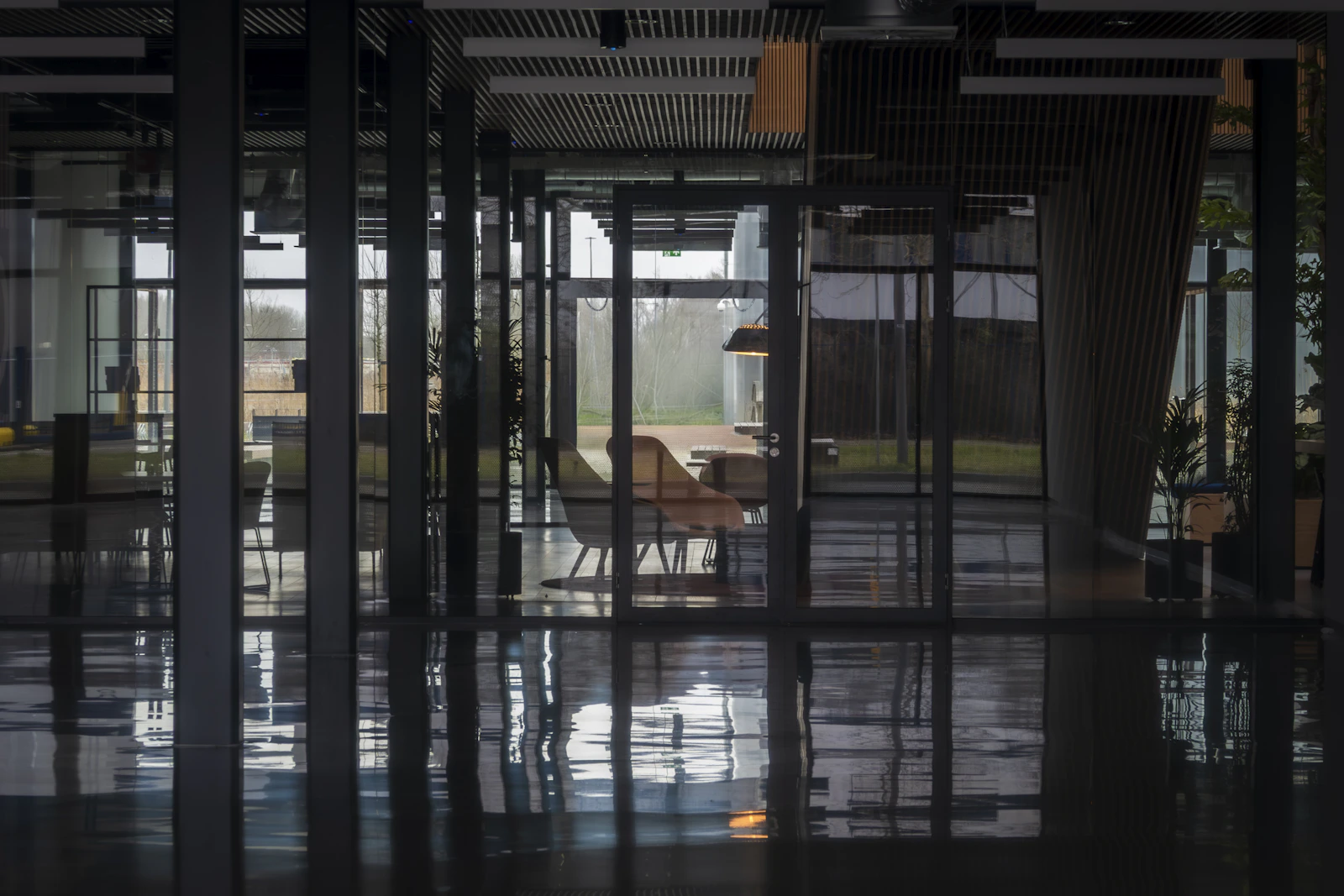 Empty modern office with glass walls and reflections, representing relationship-manager departure