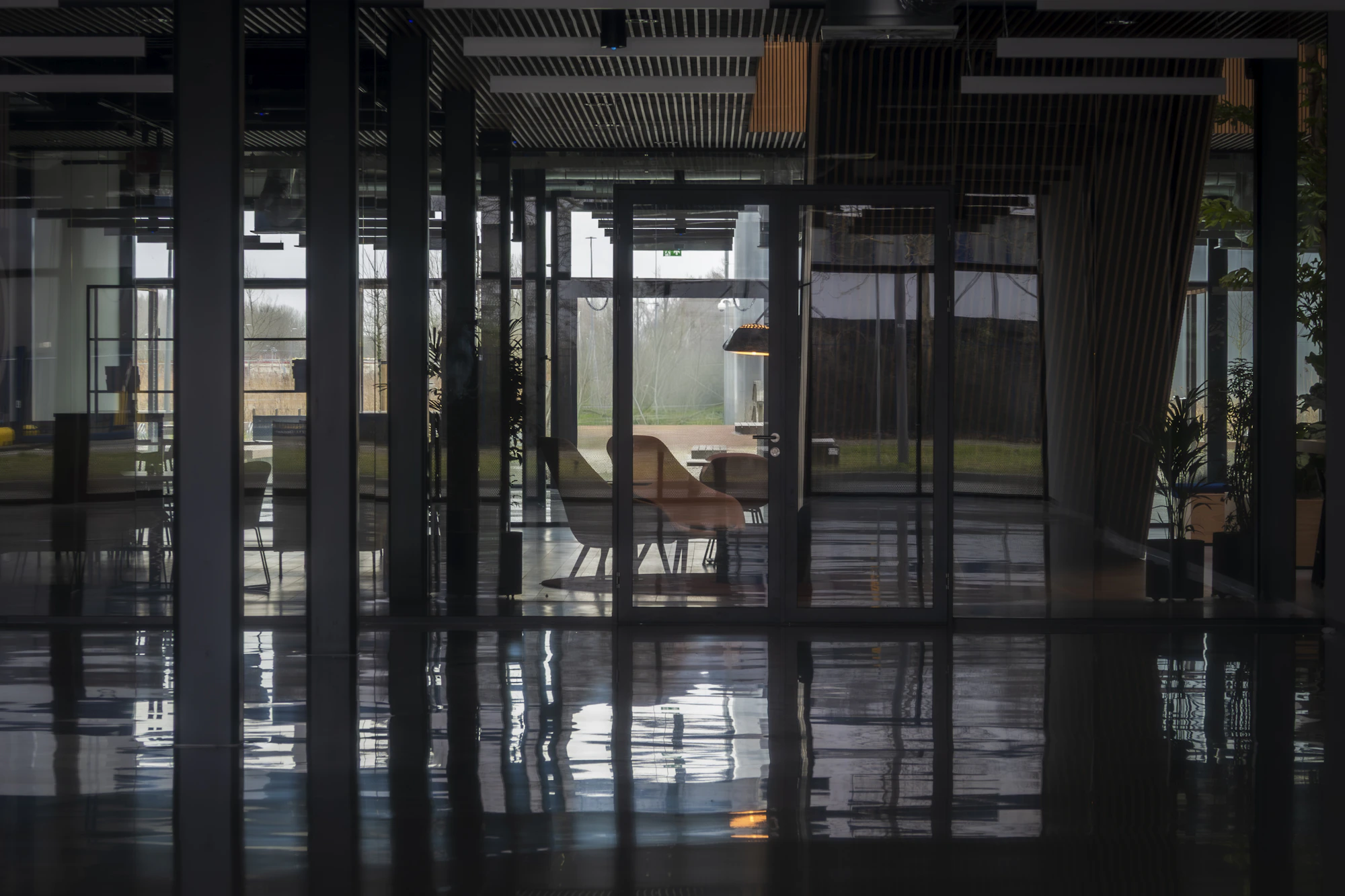 Empty modern office with glass walls and reflective flooring