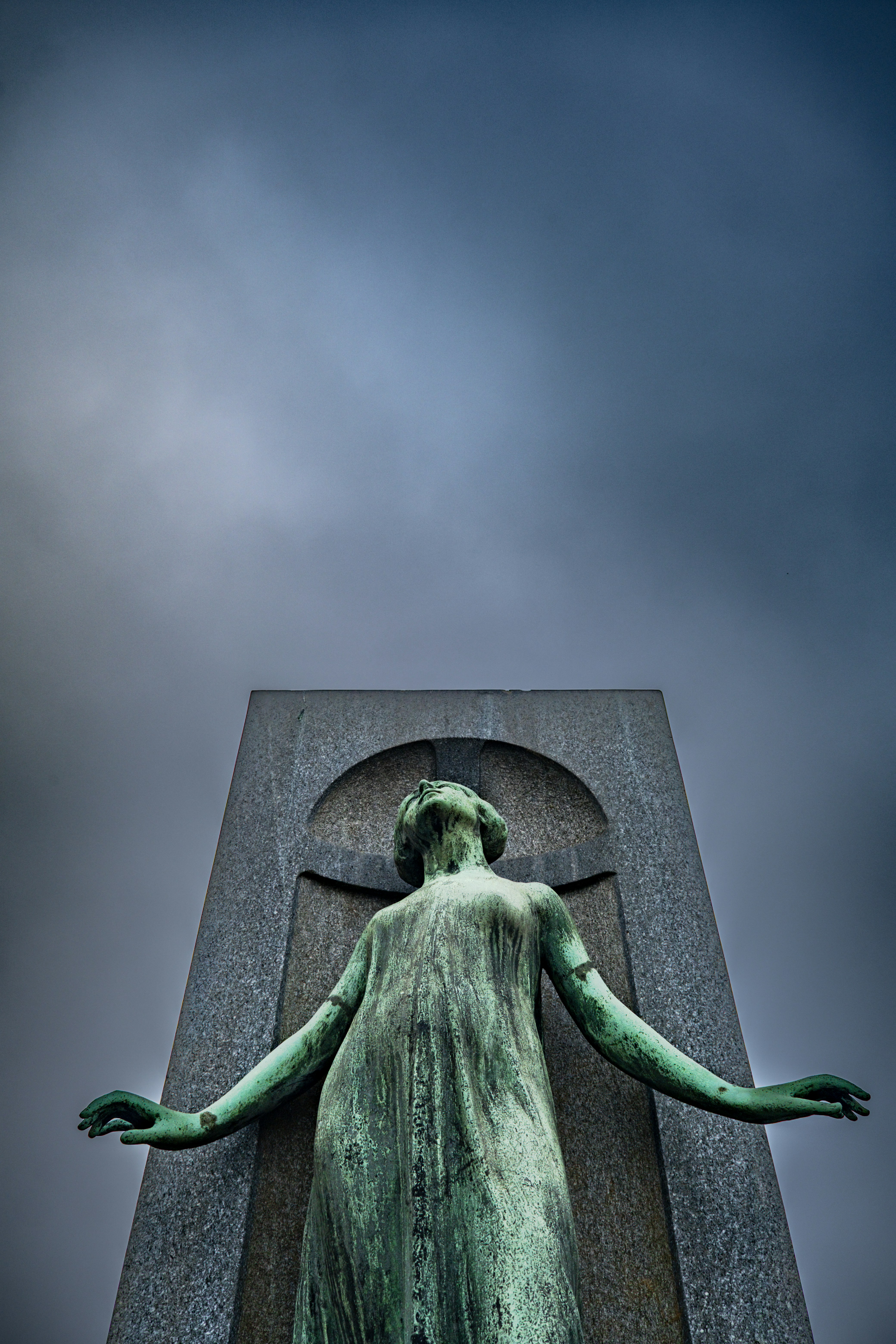 腕を広げた風化した青銅像