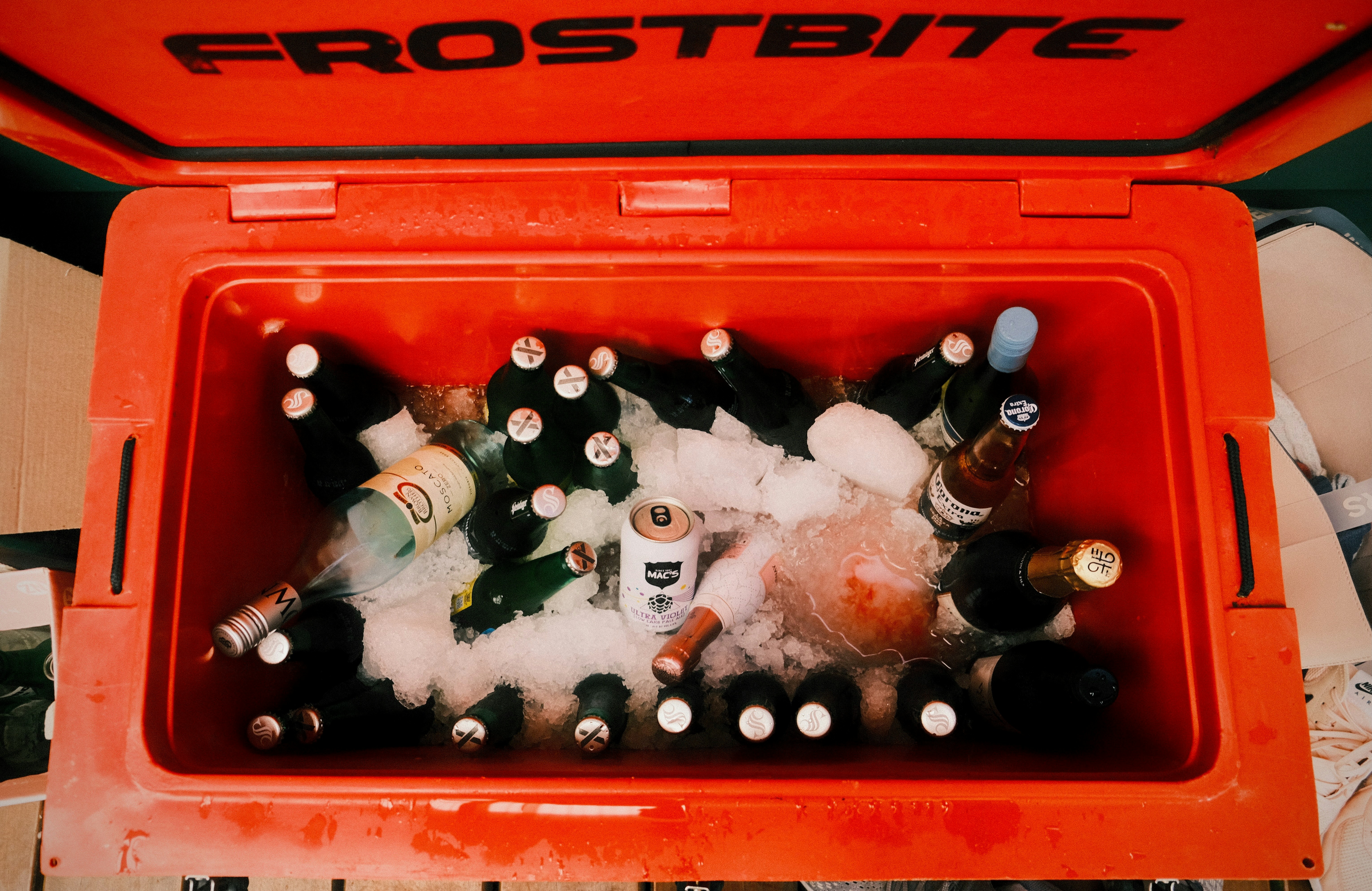 Orange cooler filled with bottles and ice