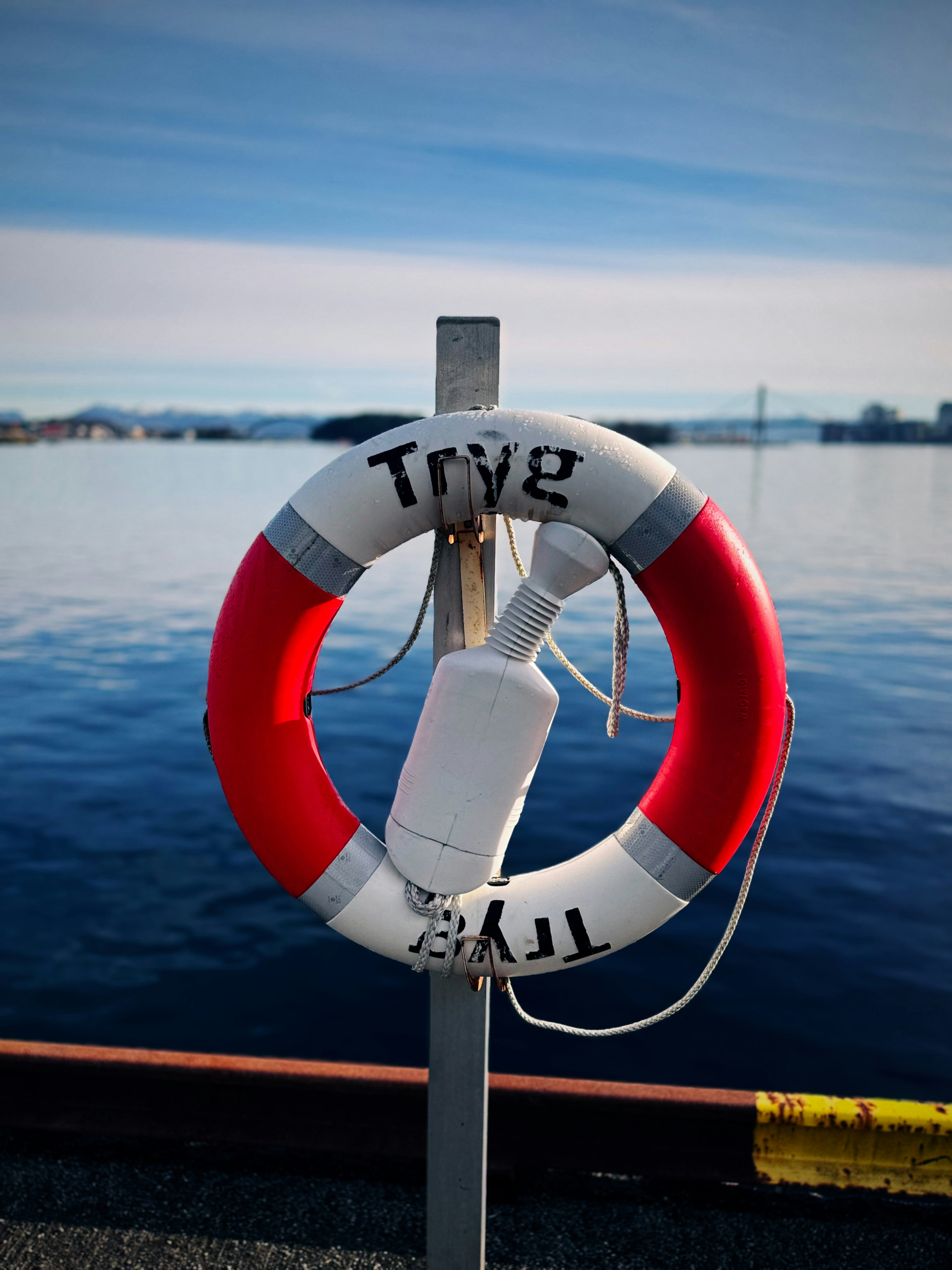 Un gilet de sauvetage est suspendu à un poteau près de l’eau.