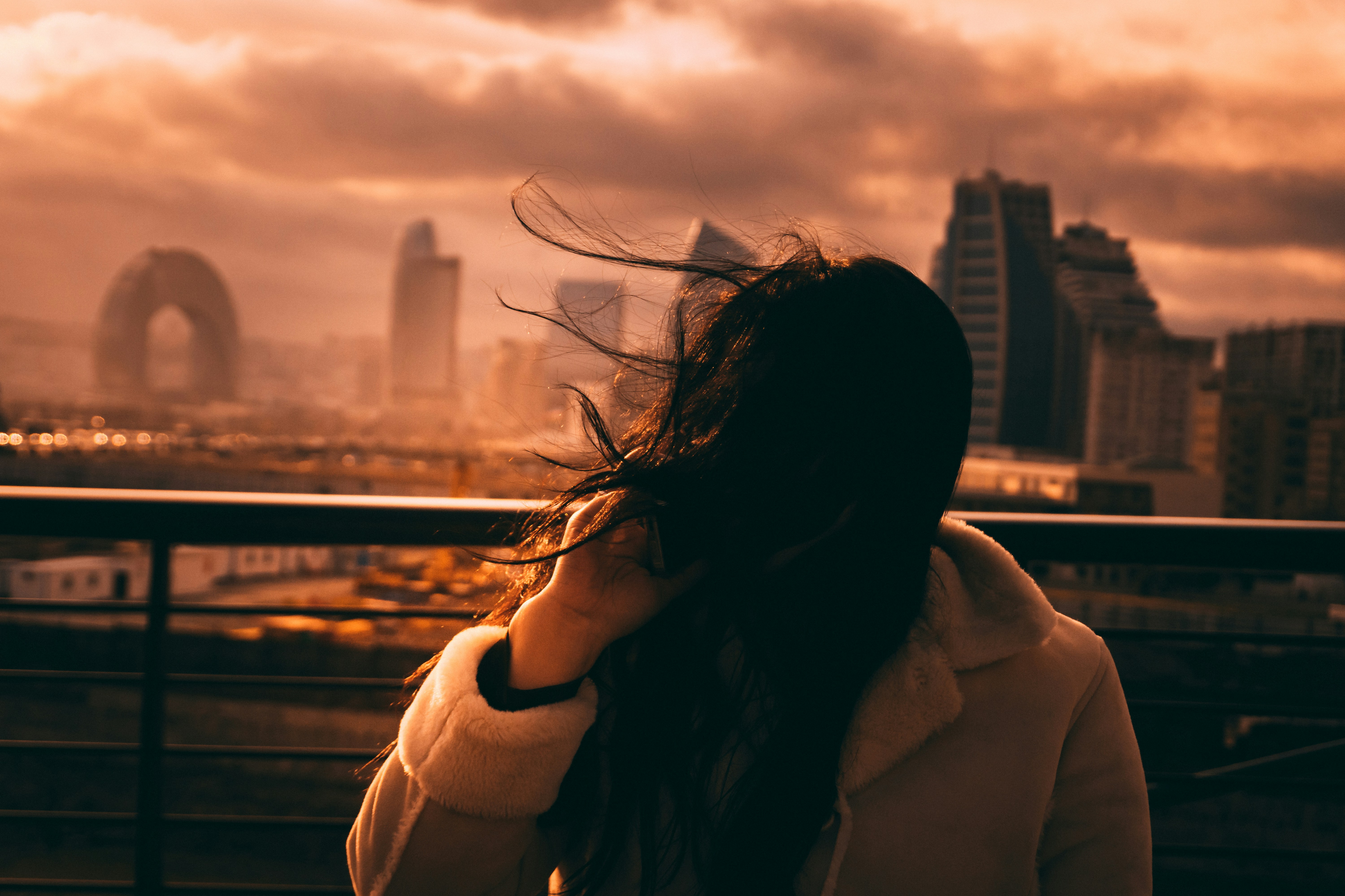 Woman with windblown hair overlooking city skyline