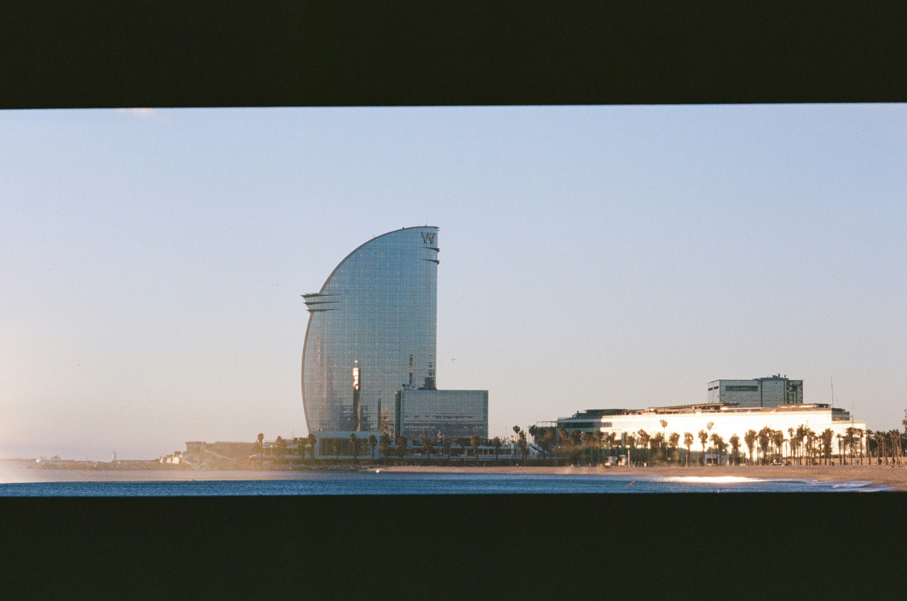Modern hotel building on a sunny beach.