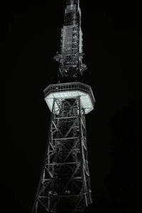 A tall tower structure against a dark night sky.