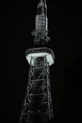 A tall tower structure against a dark night sky.