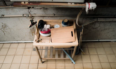 Wooden sink counter with various kitchen items.
