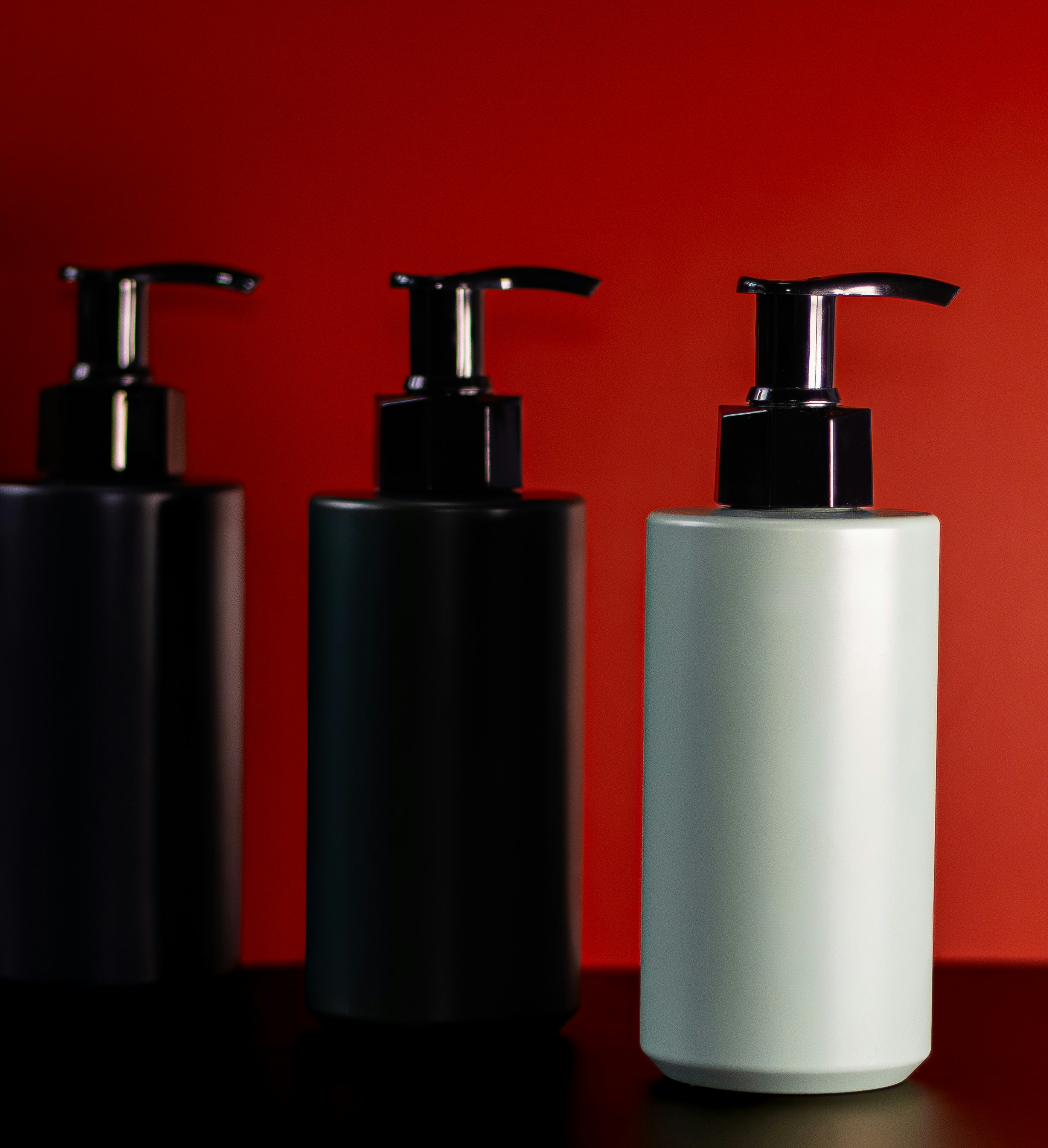 Trois bouteilles de pompe sur fond rouge