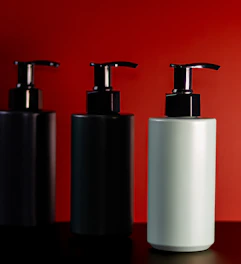 Three pump bottles on a red background