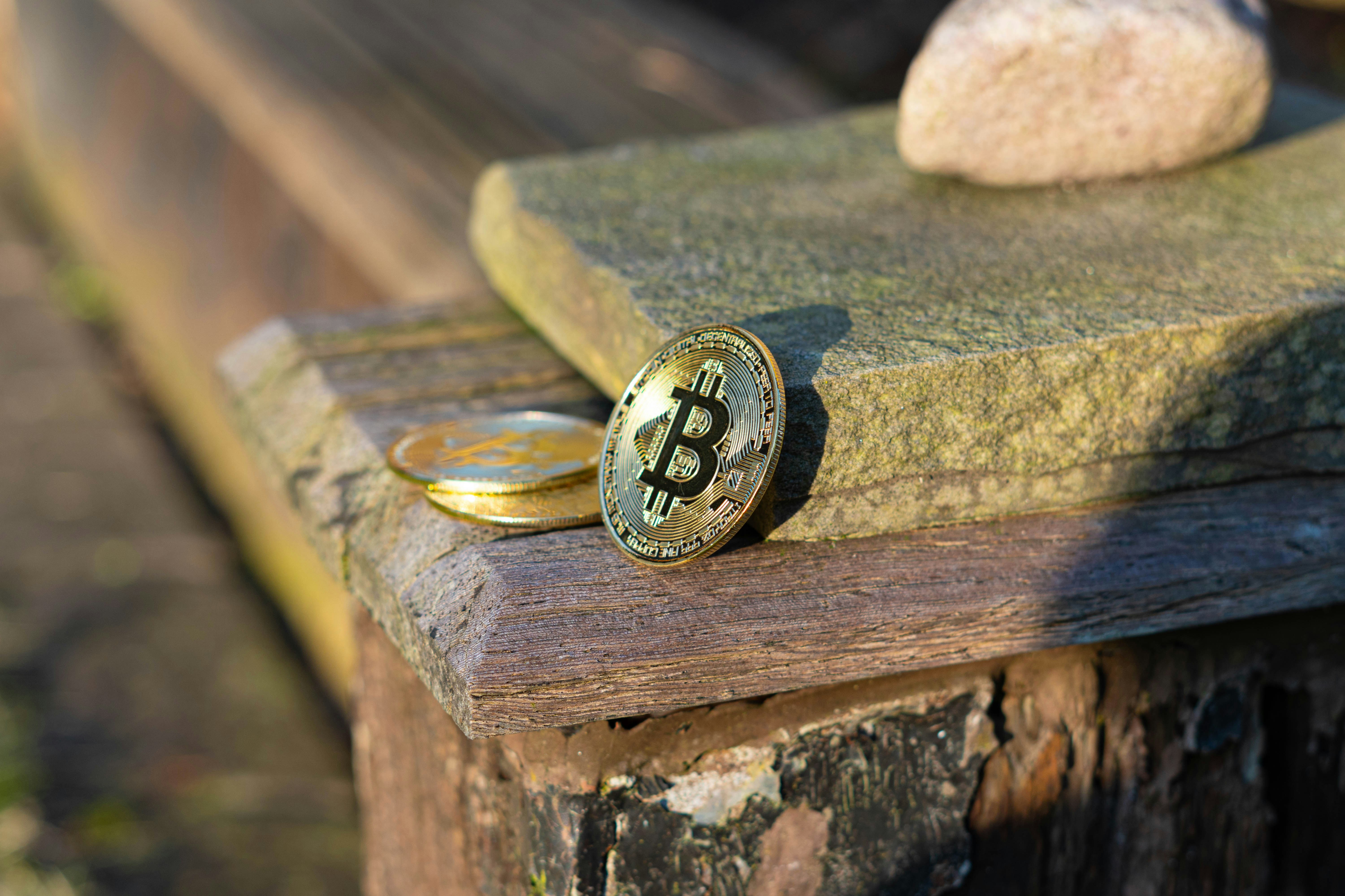Two bitcoins resting on a wooden surface
