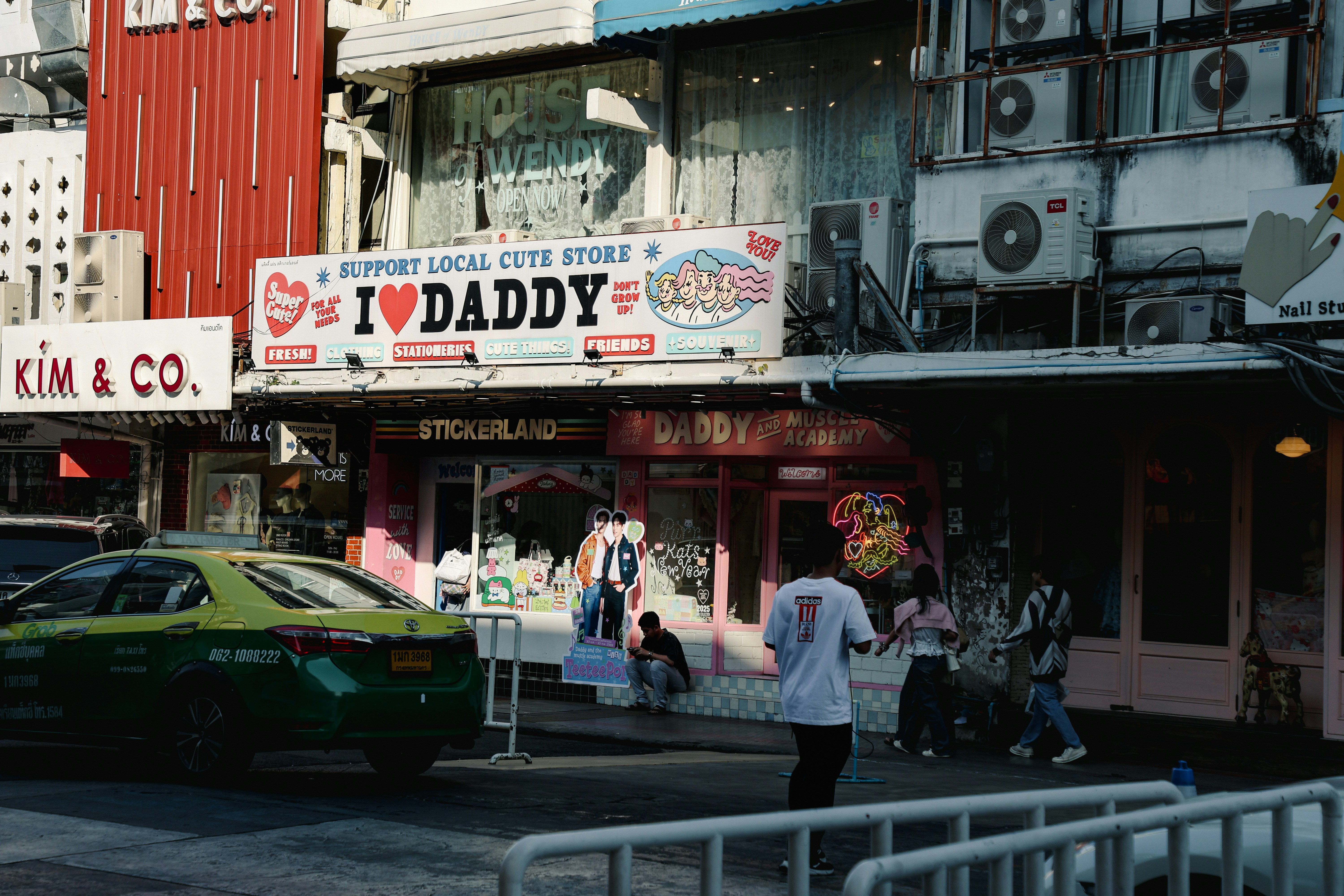 City street scene with shops and a taxi.