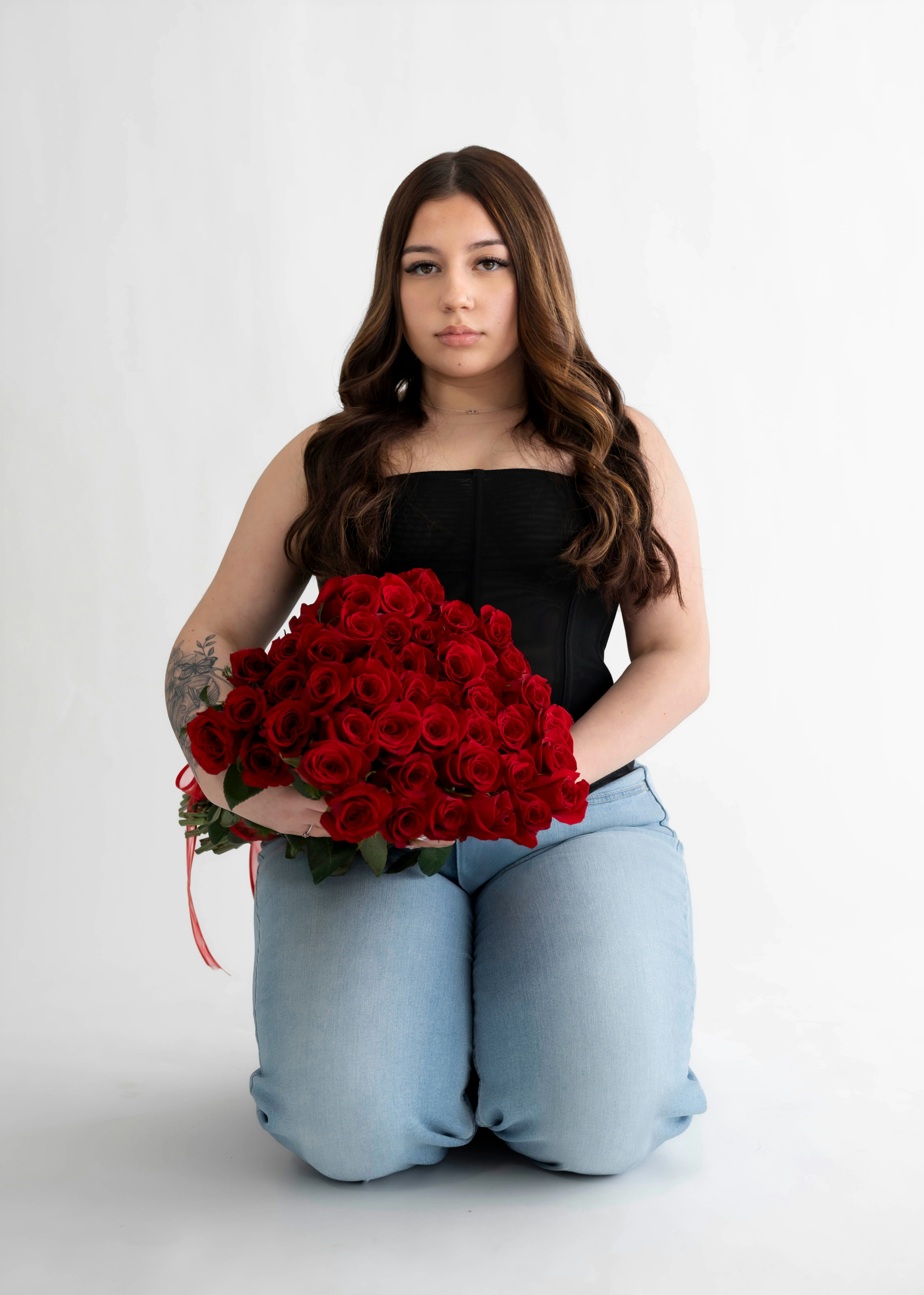 Young woman holding a large bouquet of red roses